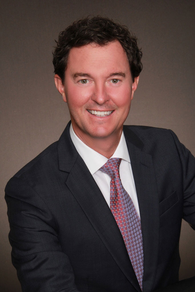 A man poses for a picture in a suit and tie