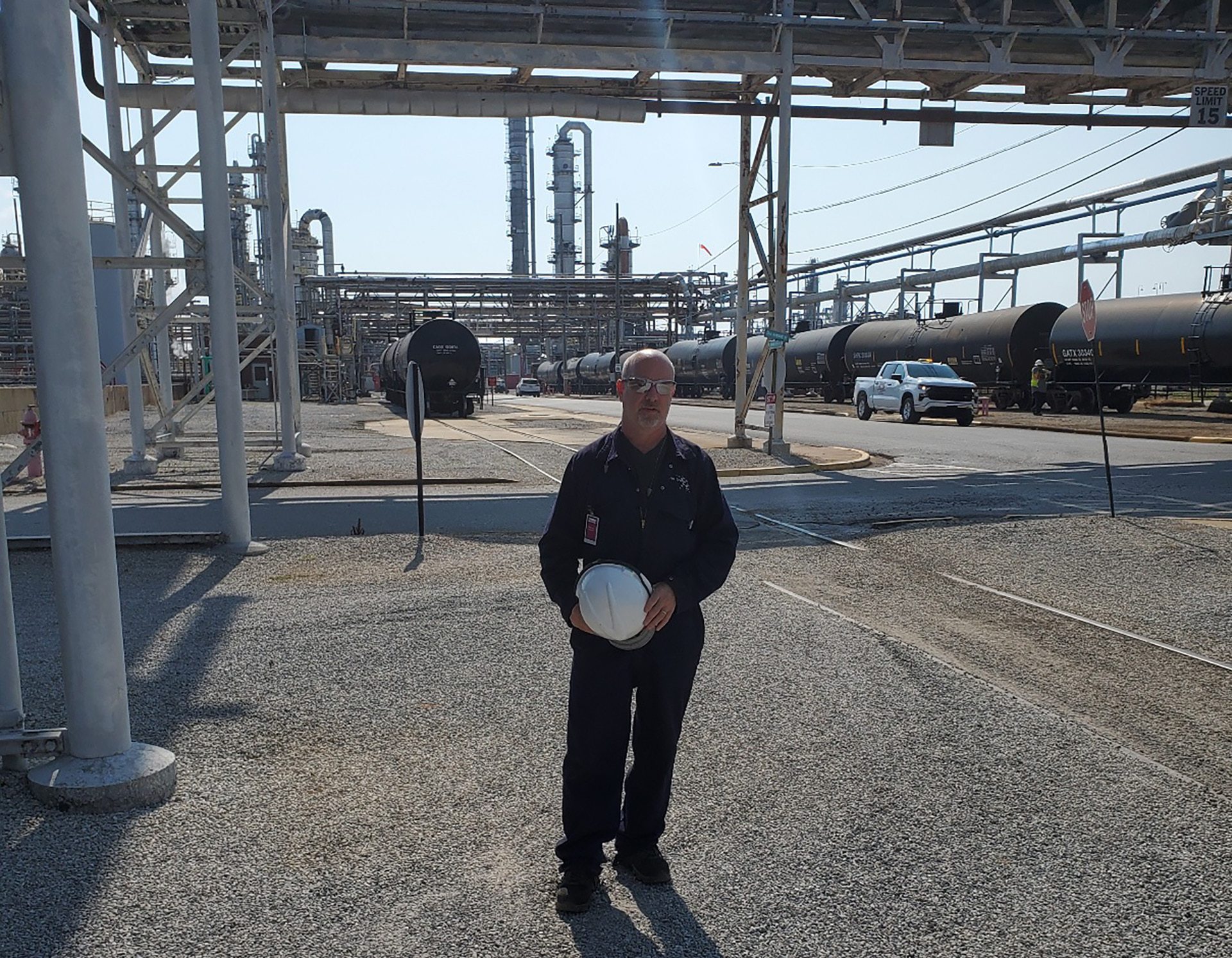 A man poses for a picture holding a hard hat