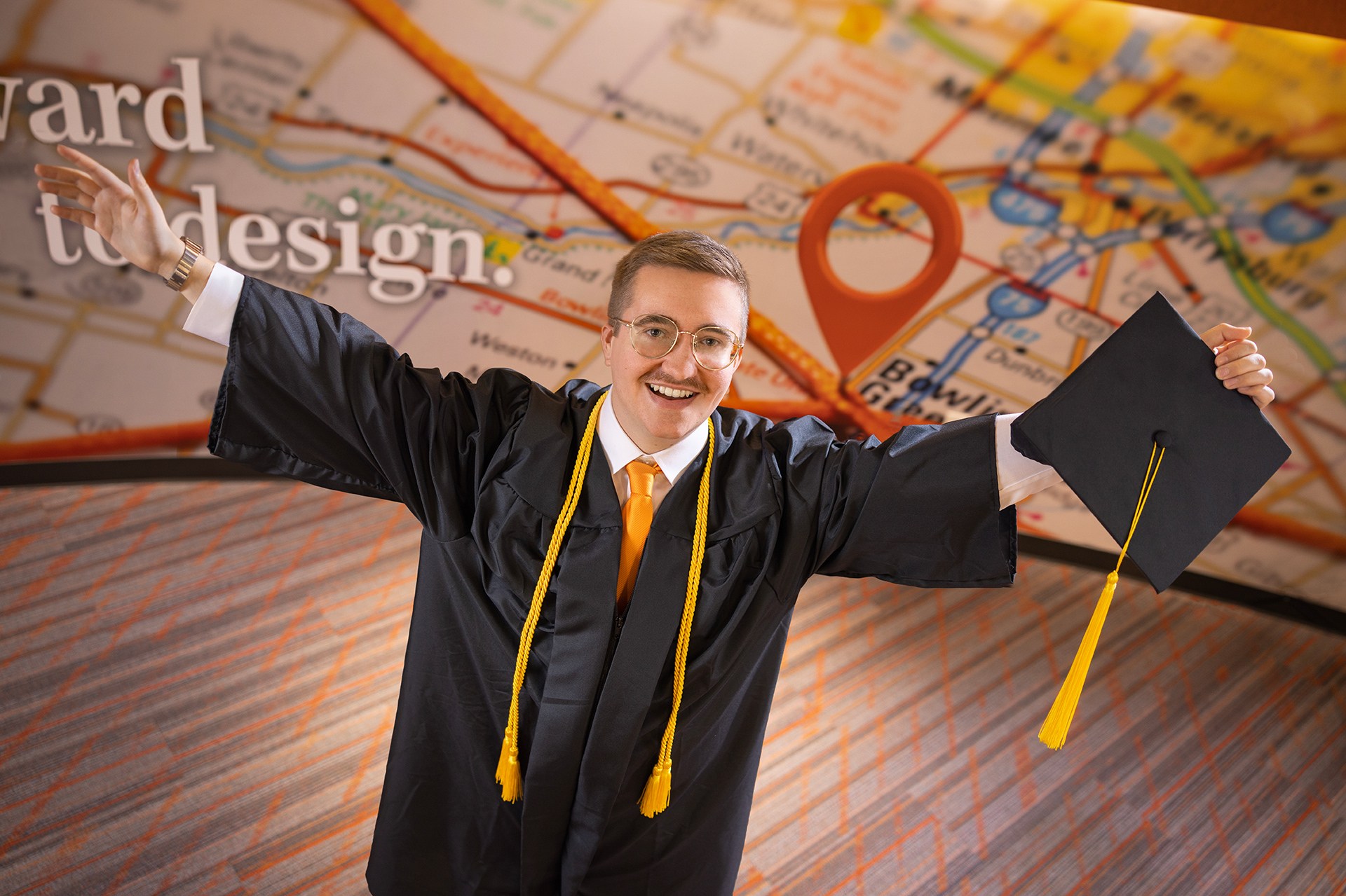 A BGSU graduate in a cap and gown in the Radbill Center for College and Life Design