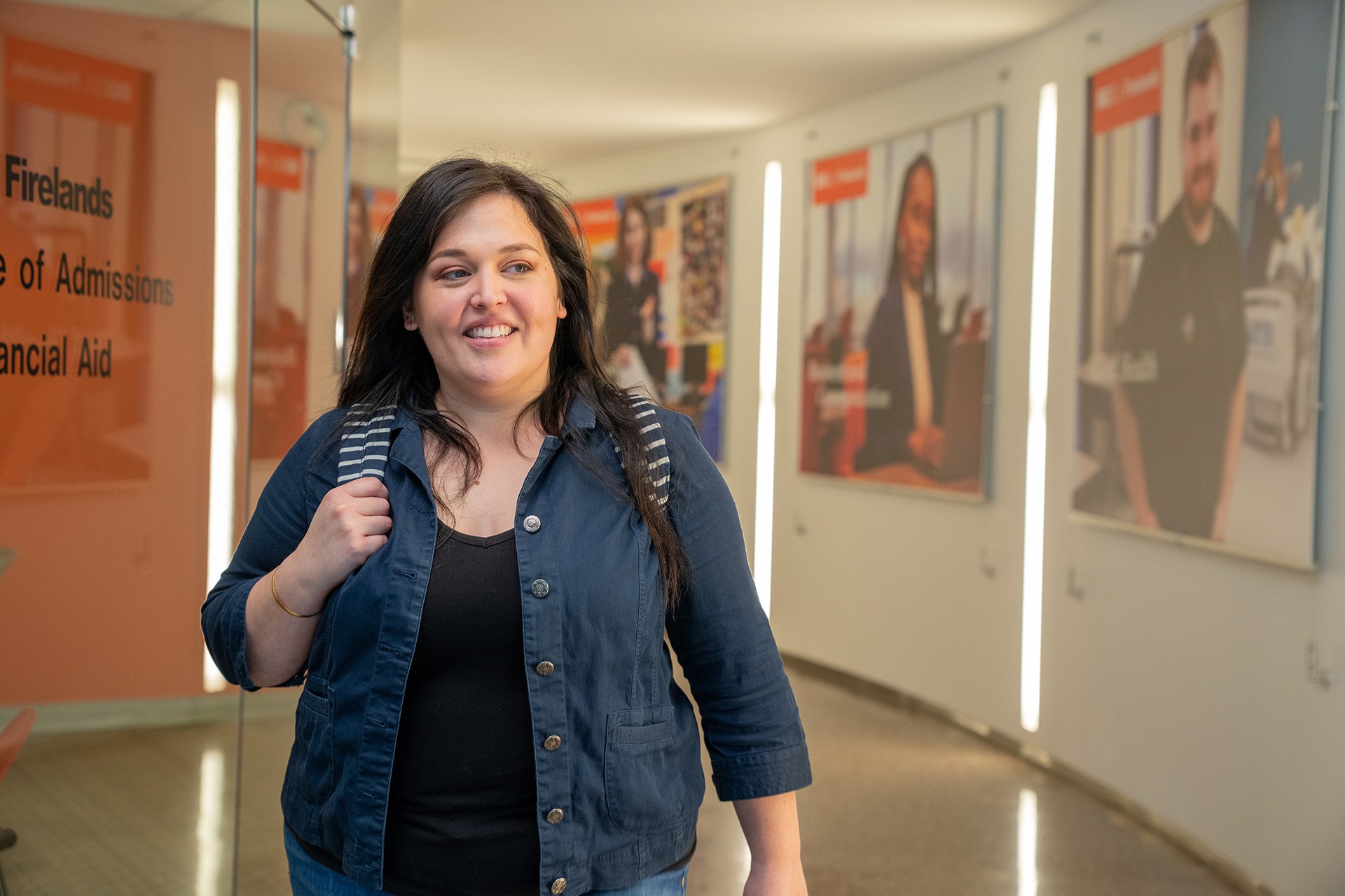 BGSU Firelands student Catalina Ari walks in the hallway outside of the admissions office while holding her bookbag at the Firelands campus.