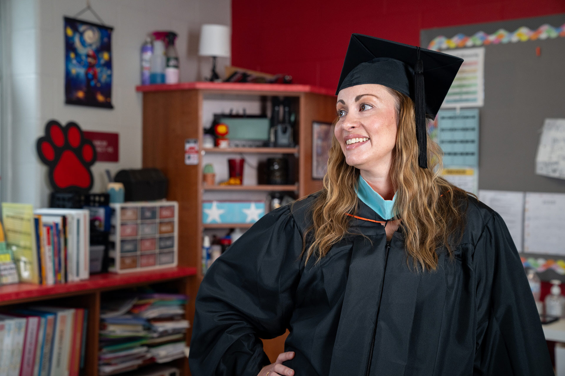 A person poses in a cap and gown.