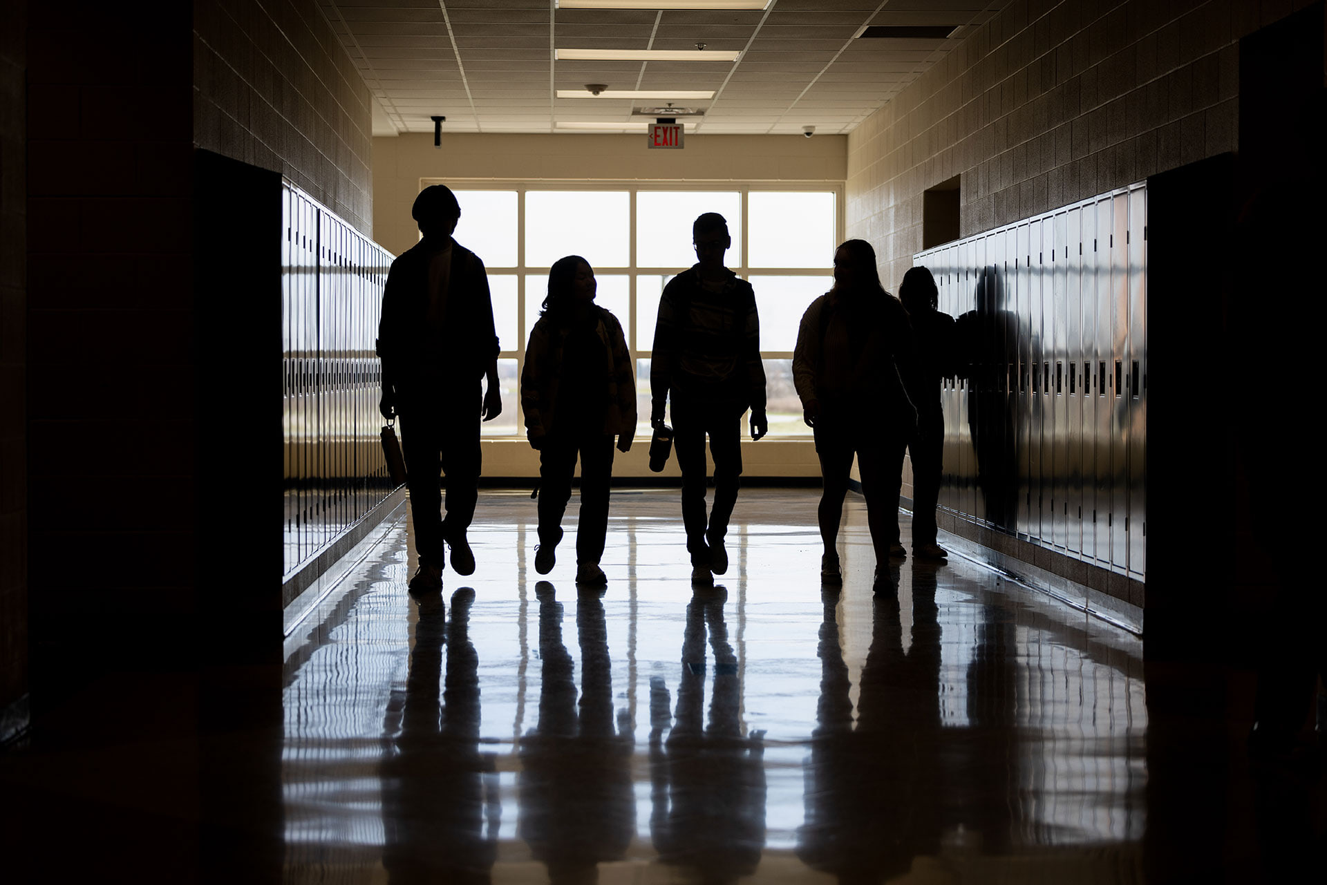 Students walk down a hallway in a school.