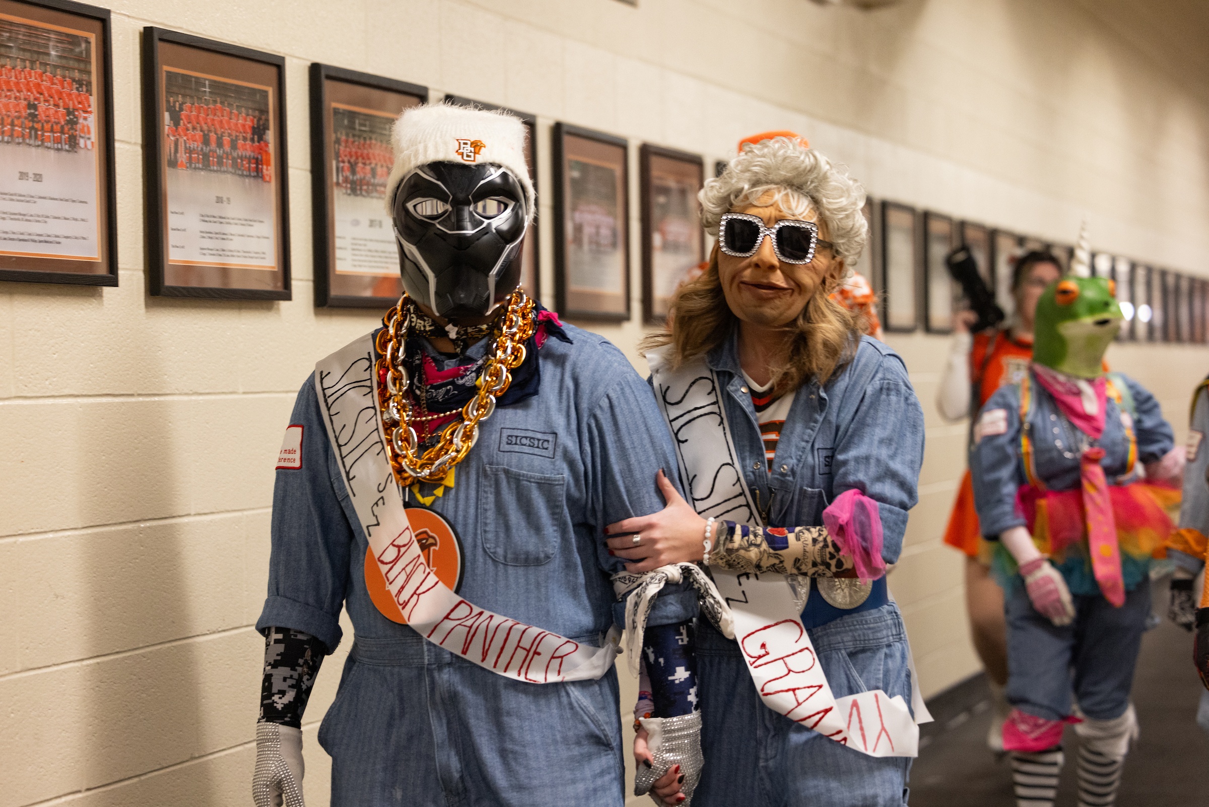 Two students wearing masks as members of SICSIC walk down a hall