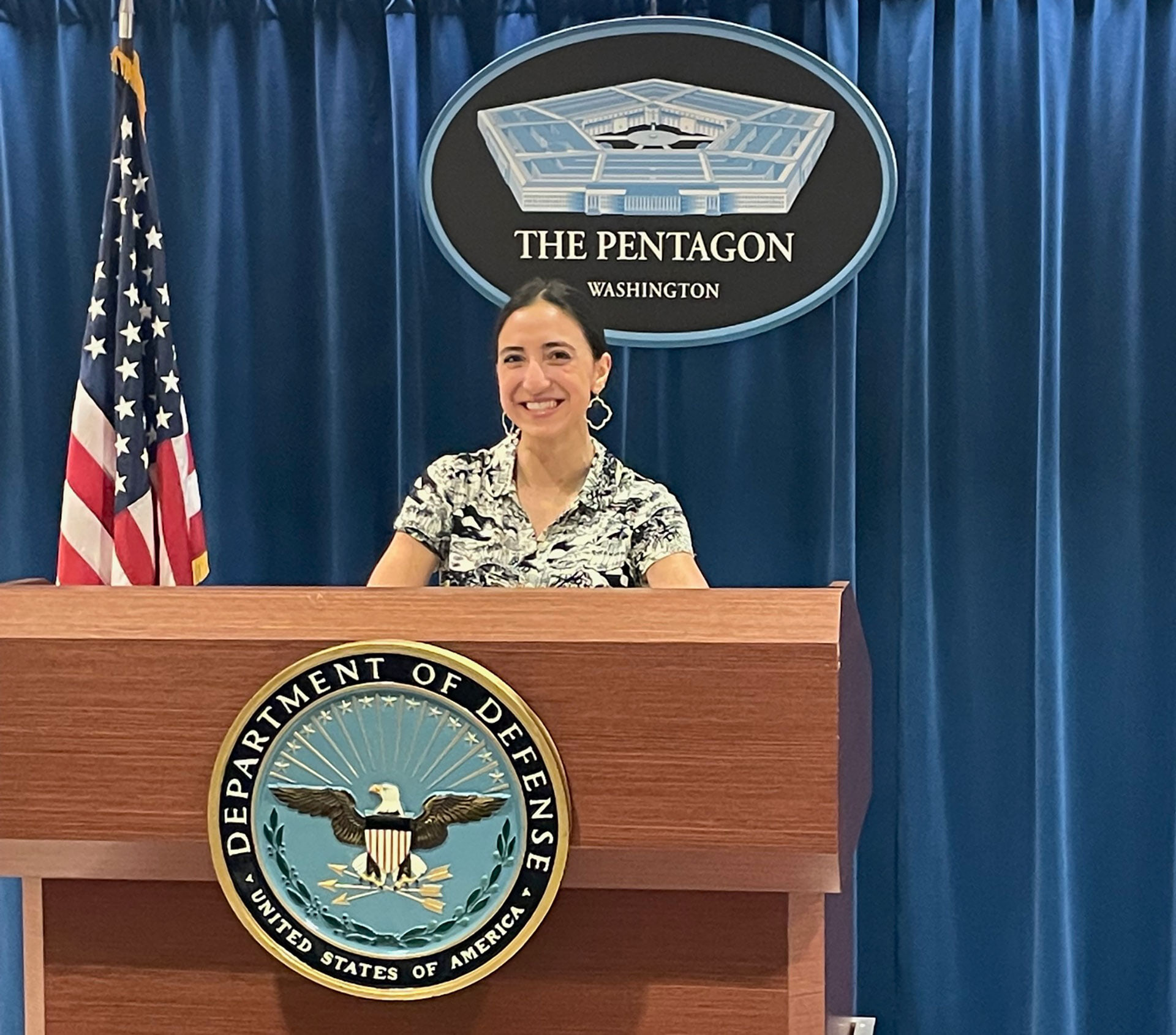 A person poses for a picture behind a podium