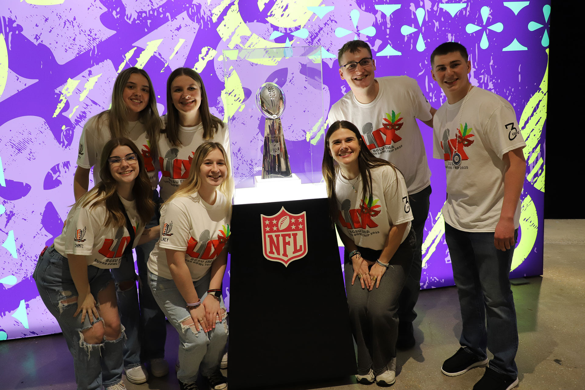 Students stand near a trophy.