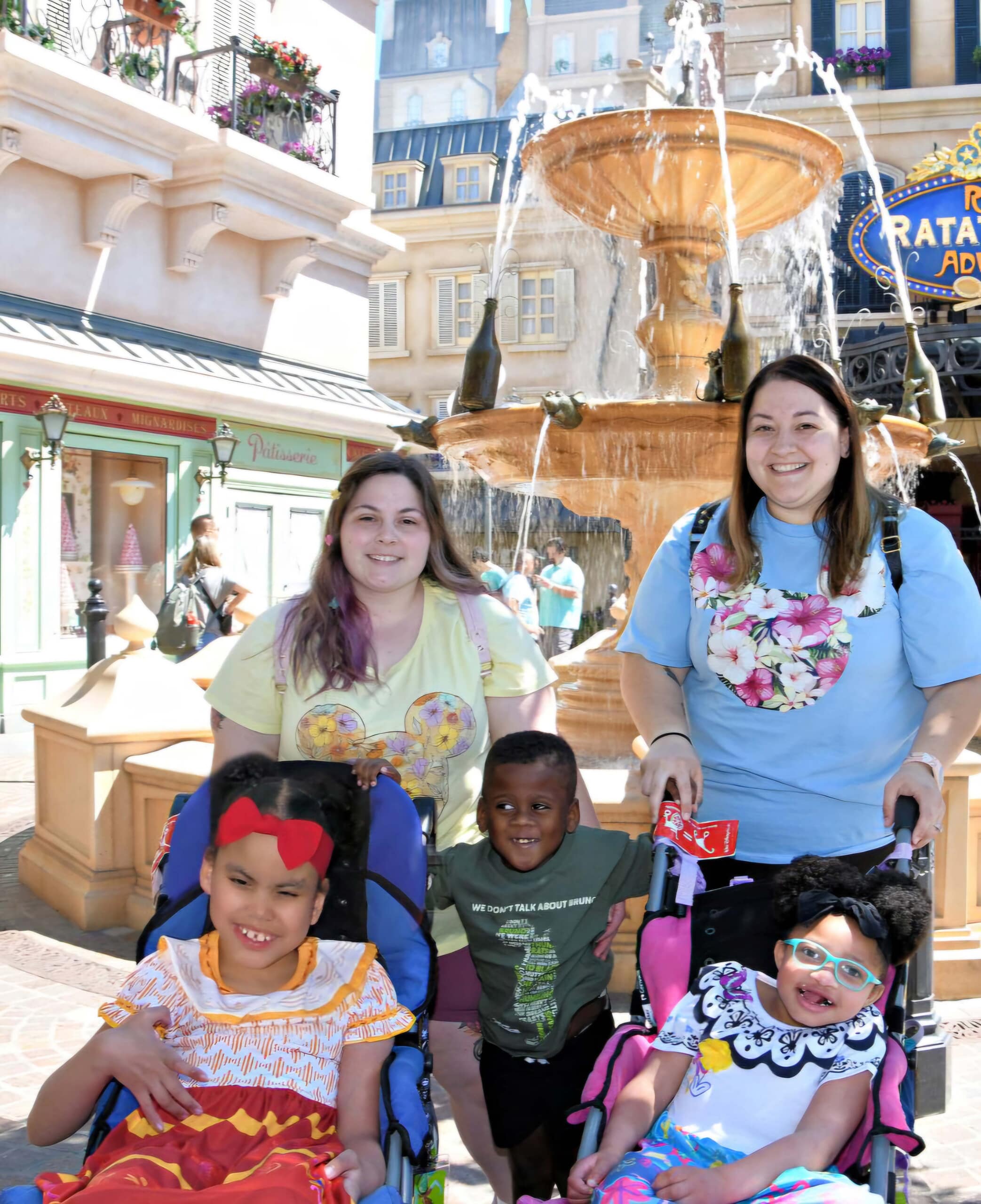 A family of five poses for photo in front of a fountain.