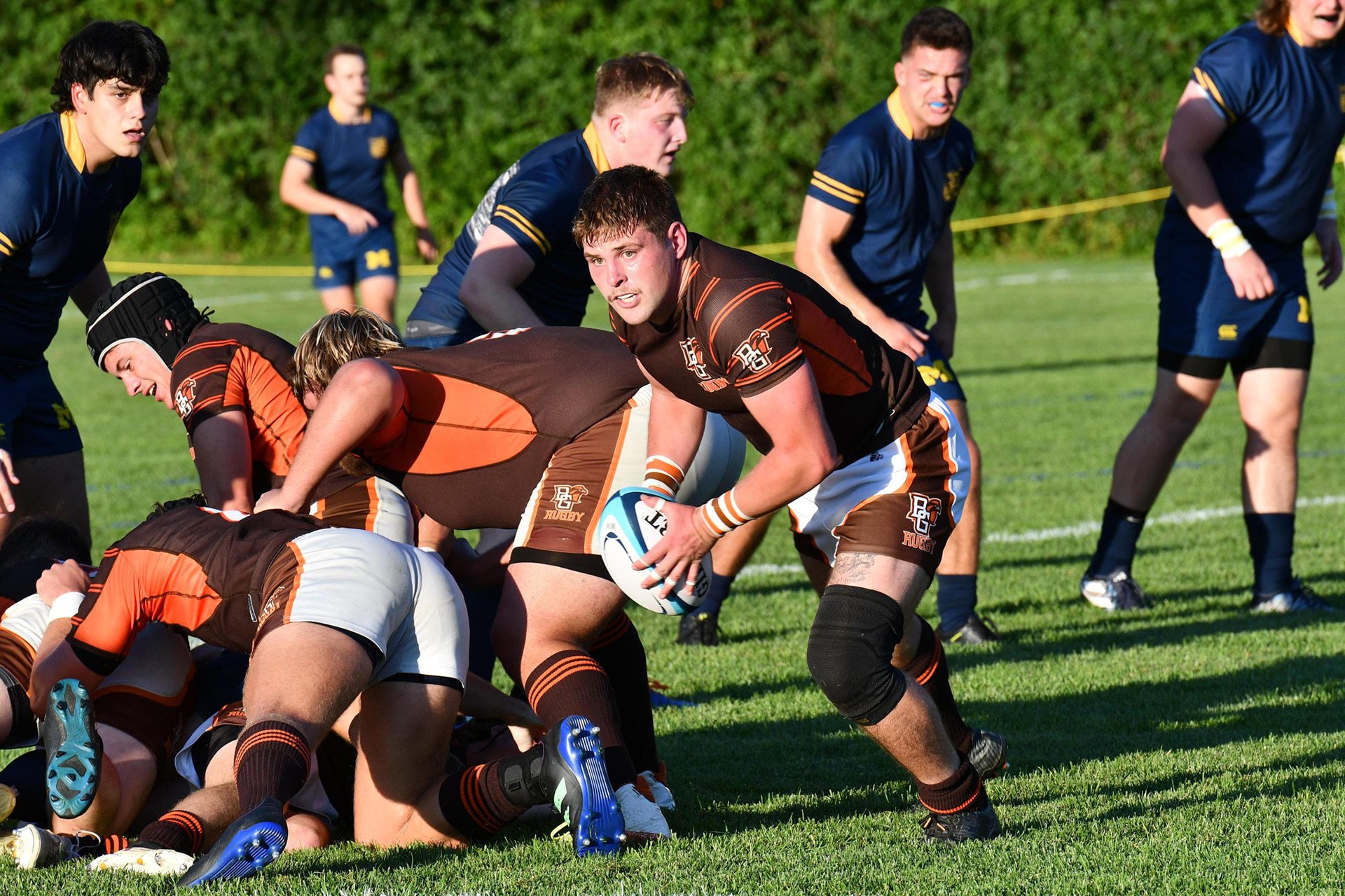 A rugby player runs with the ball.