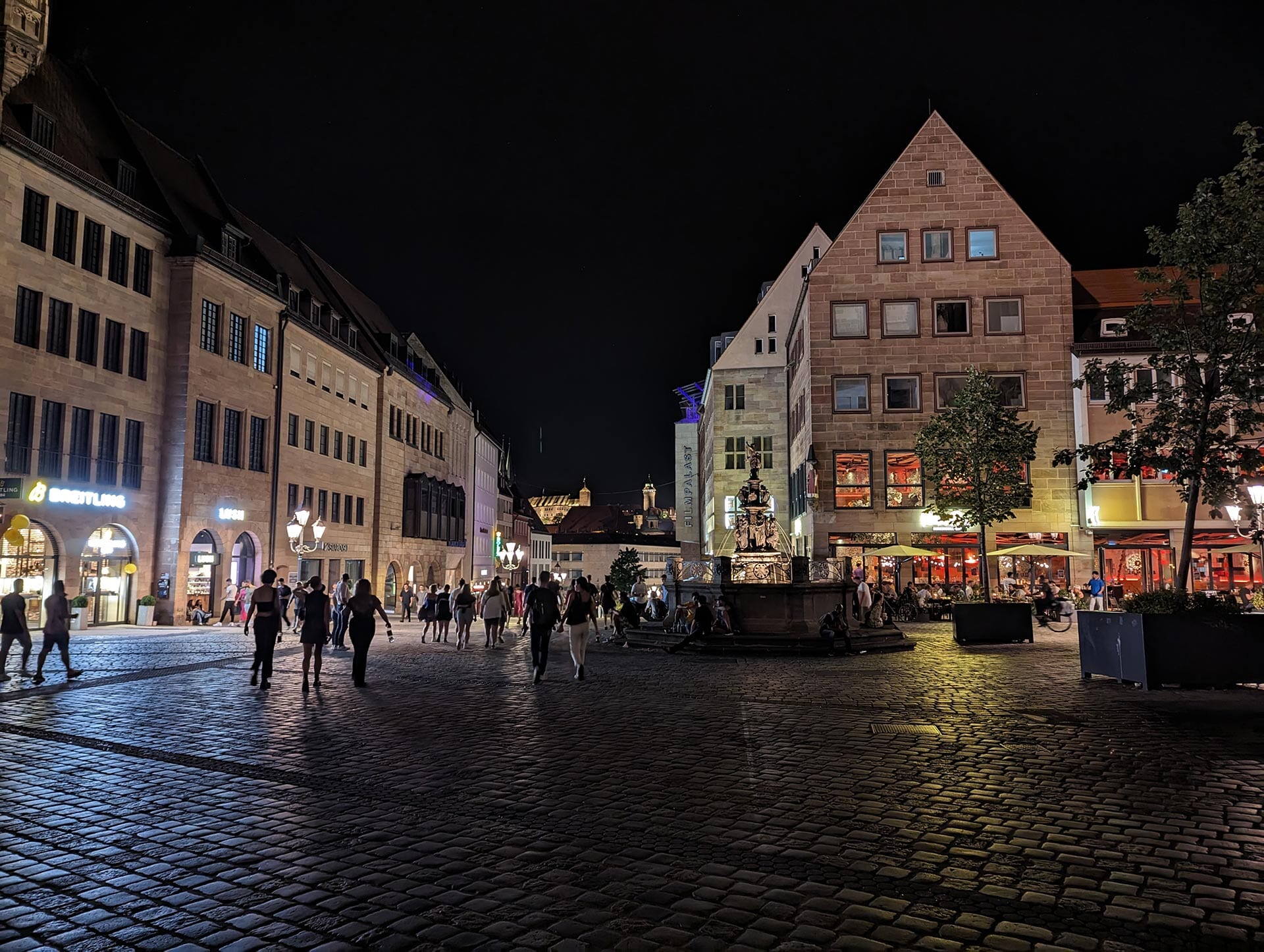 People walking in a town square at night