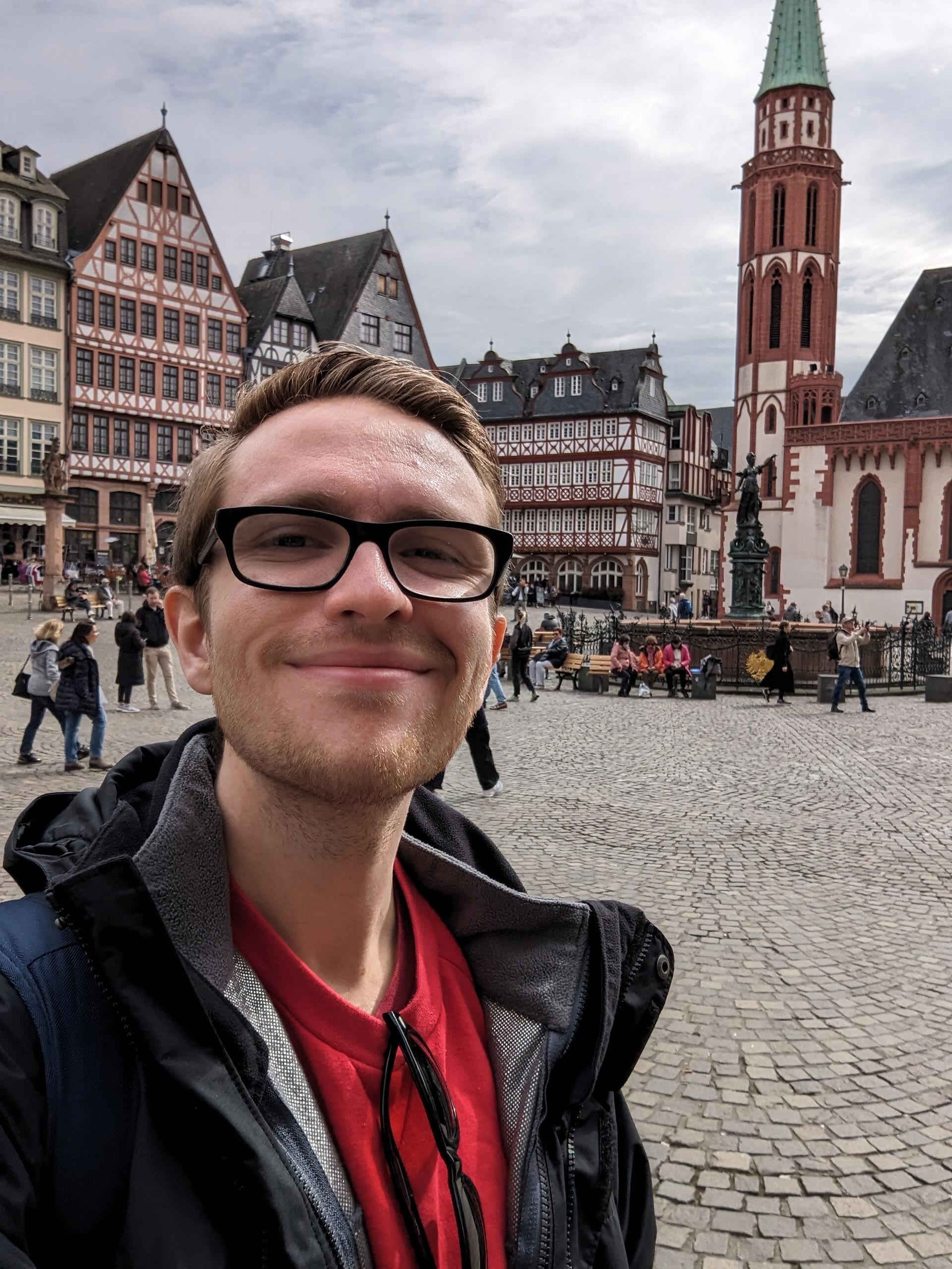 A man poses for a picture in front of Old St. Nicholas Church in Frankfurt Germany