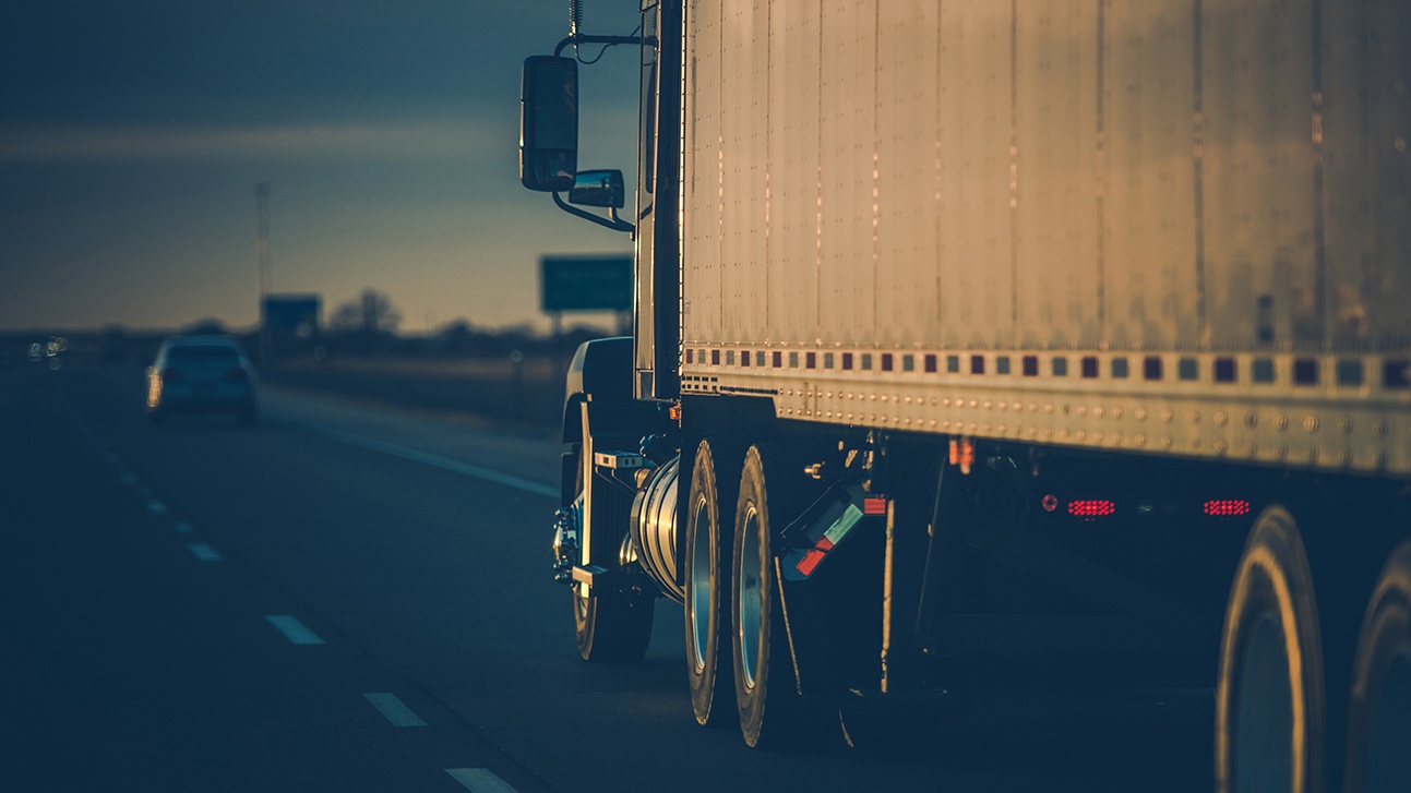 A semi-truck travels down a highway