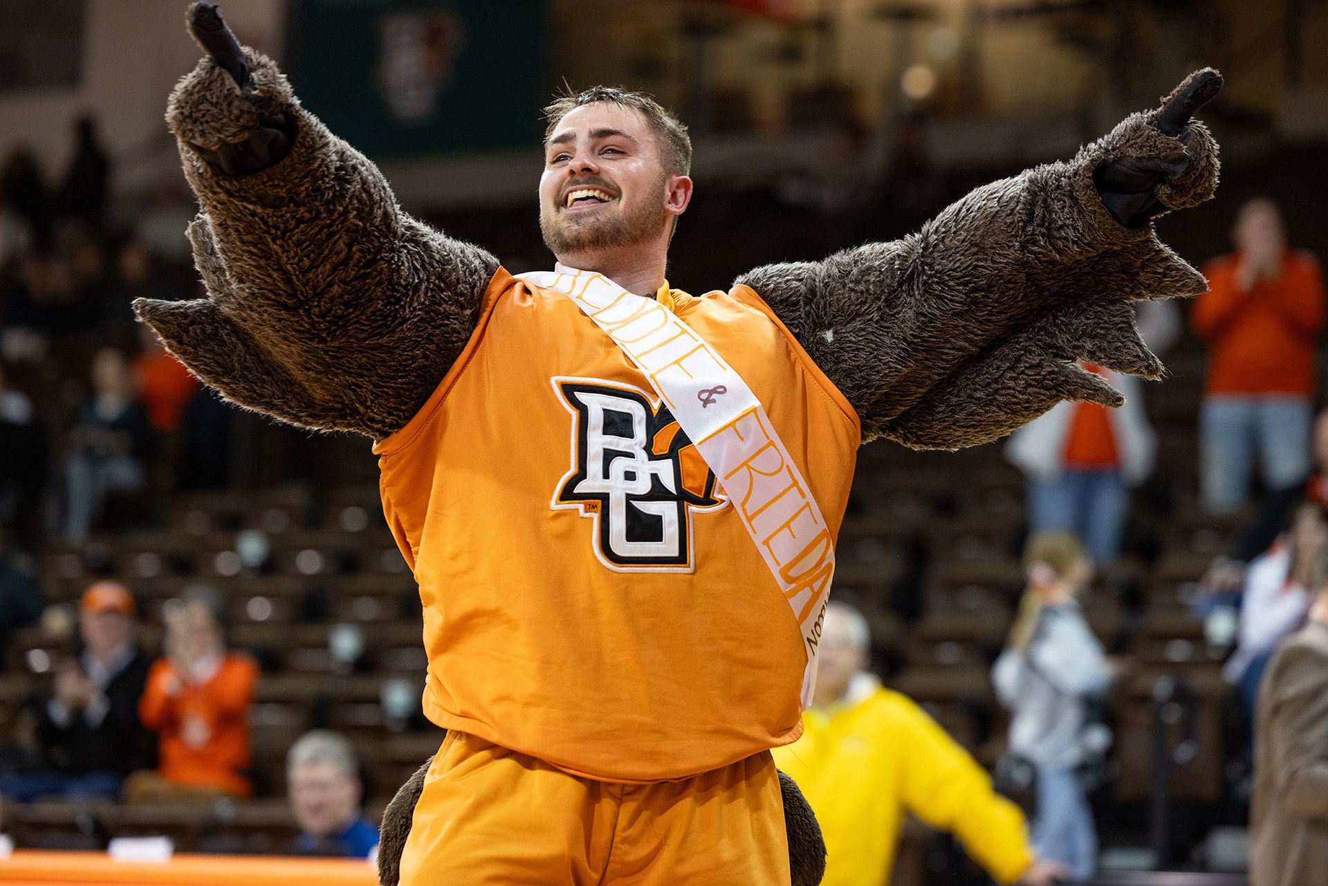 A college student is unmasked as a mascot while still wearing the mascot uniform