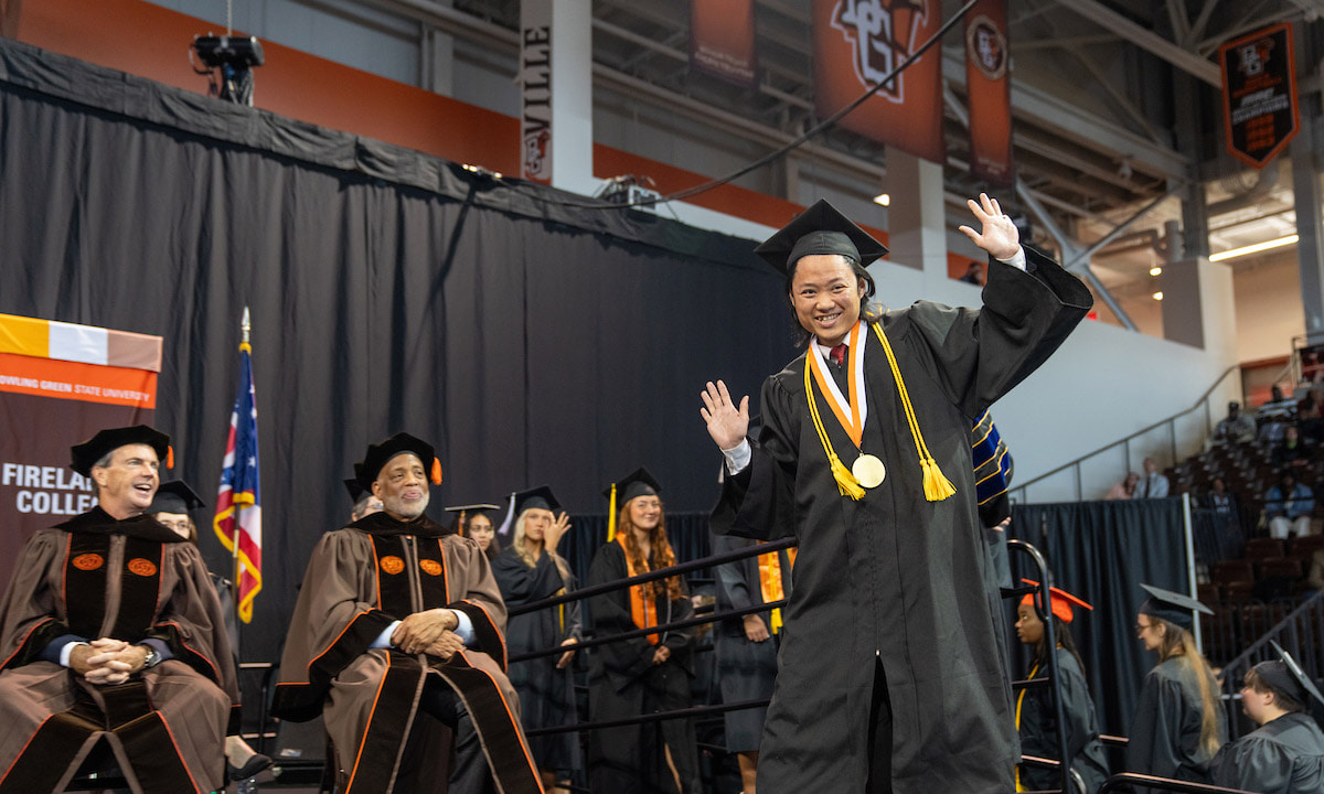 A person celebrates on the BGSU Commencement stage.