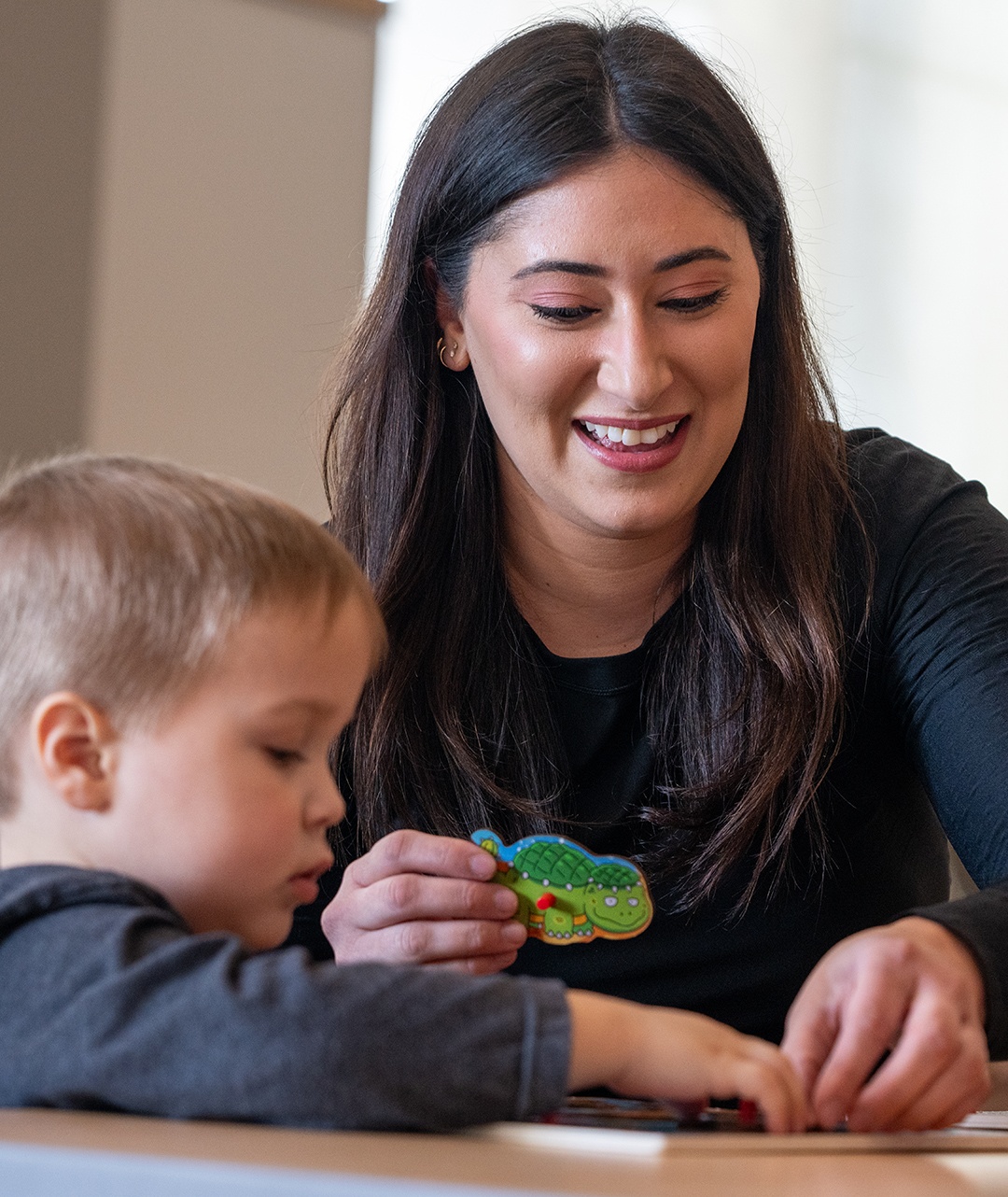 A person doing a puzzle with a child.