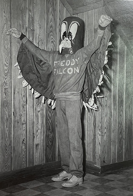  A person stands in a falcon costume