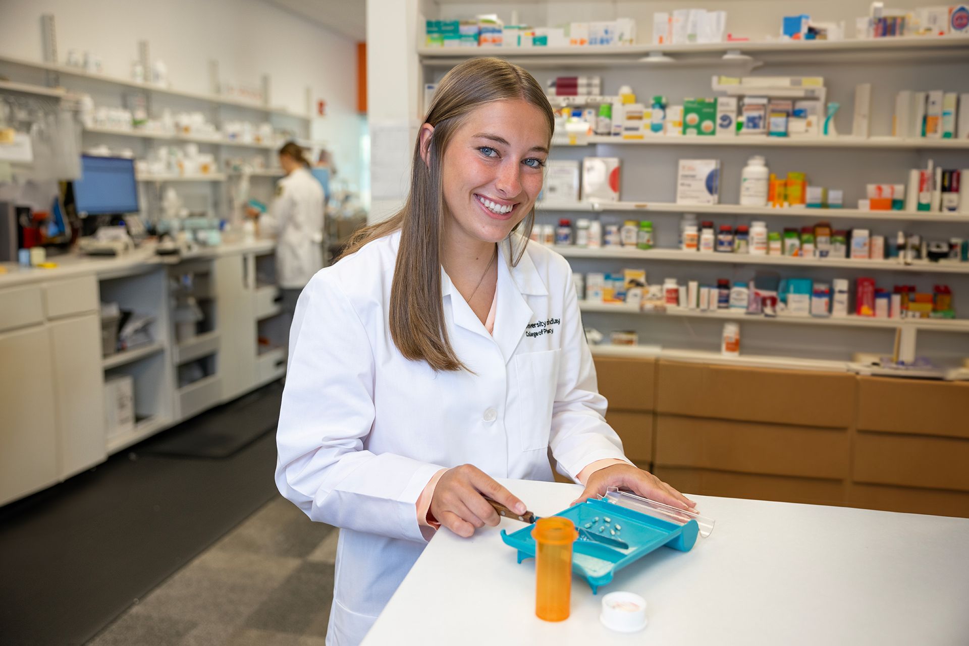 A pharmacist counts pills in a pharmacy