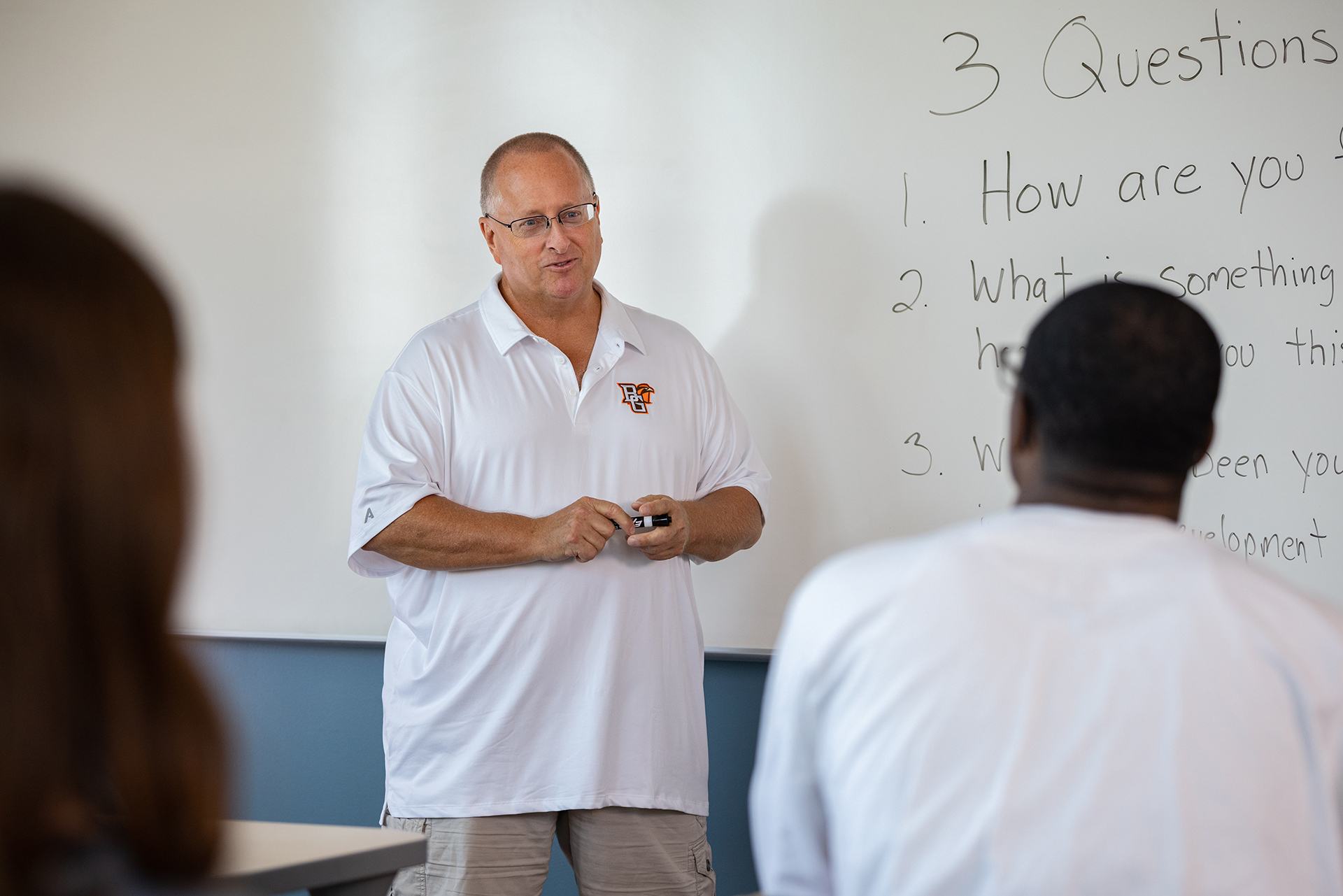 A person talks to a group of people in a classroom