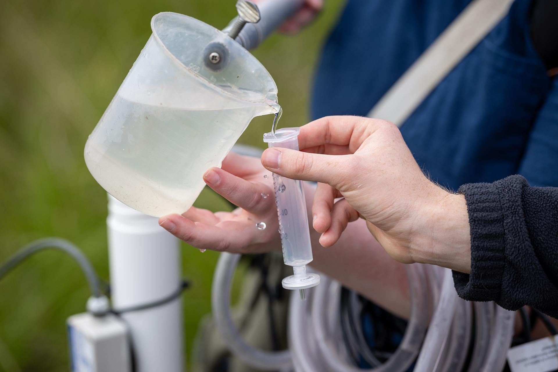 Water is poured from a beaker to a collection tube for testing