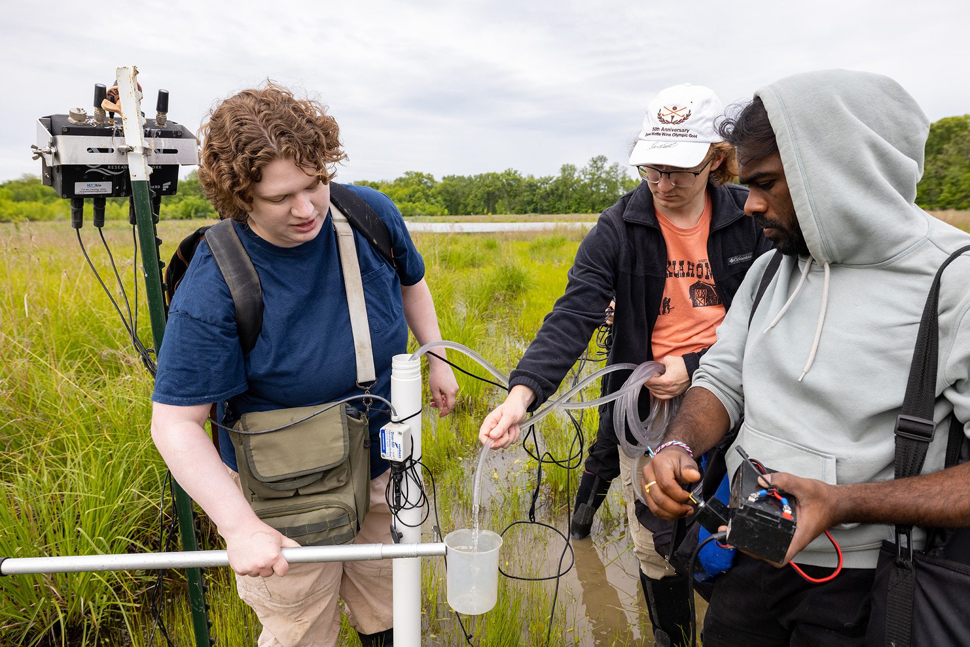 Three researchers collect and test water samples