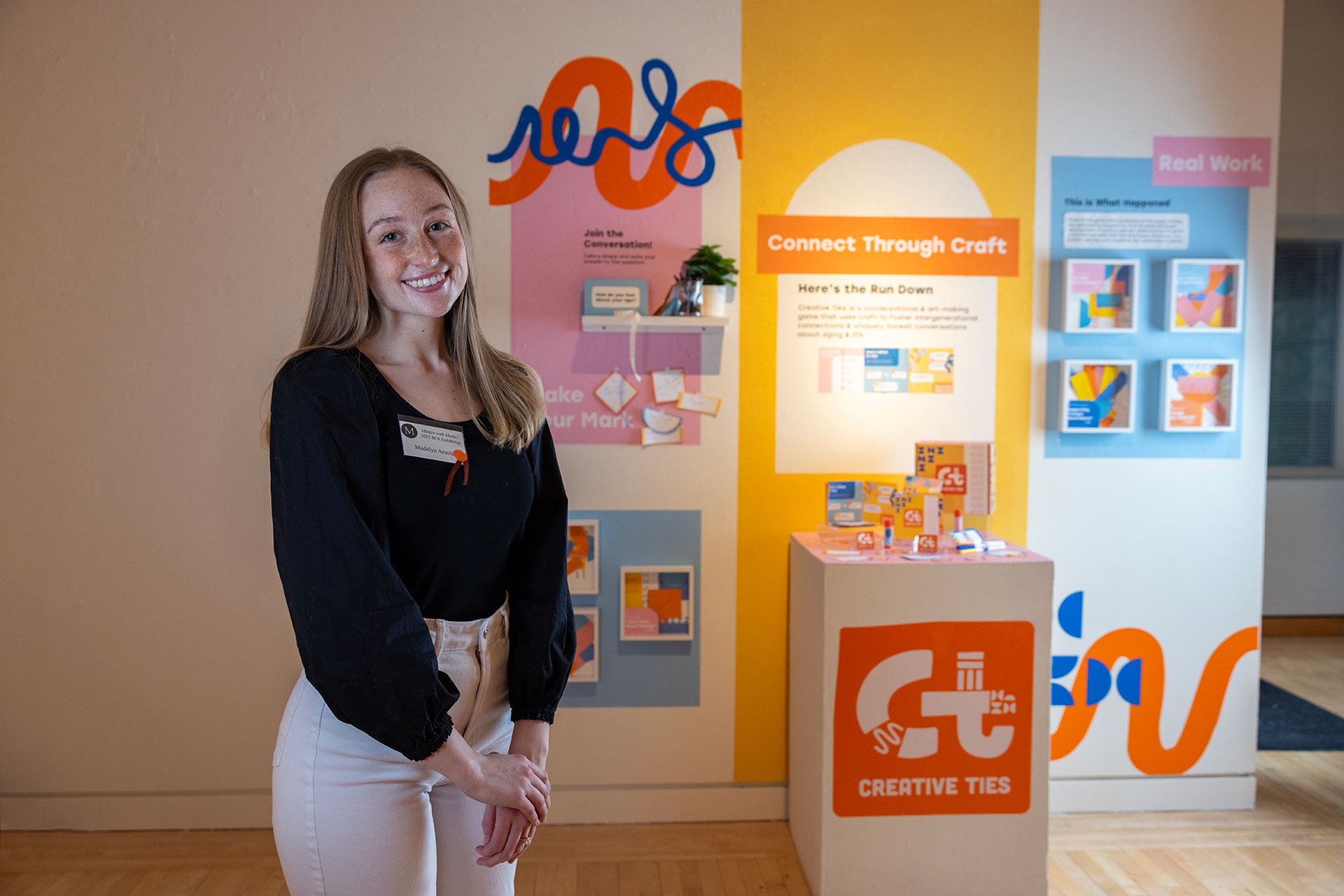 A person stands in front of a graphic design art display