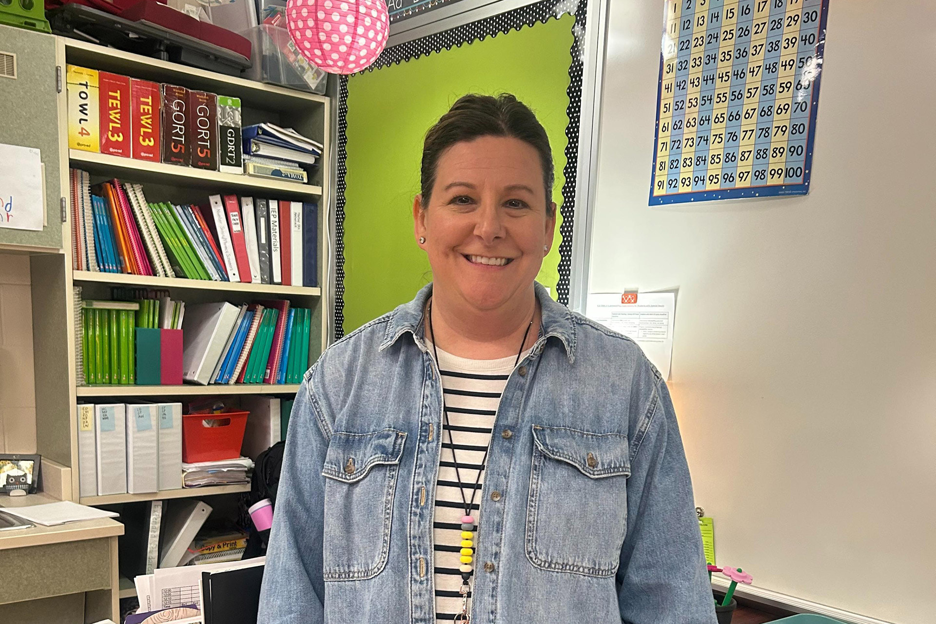 A teacher stands in a classroom.