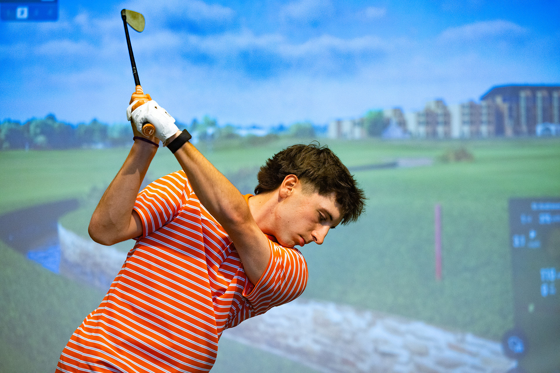 A golfer swings a club. 