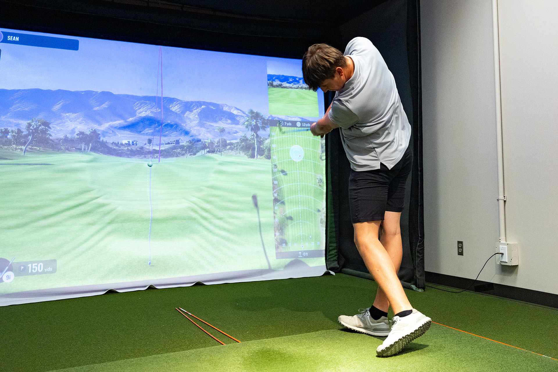 A golfer hits a tee shot.