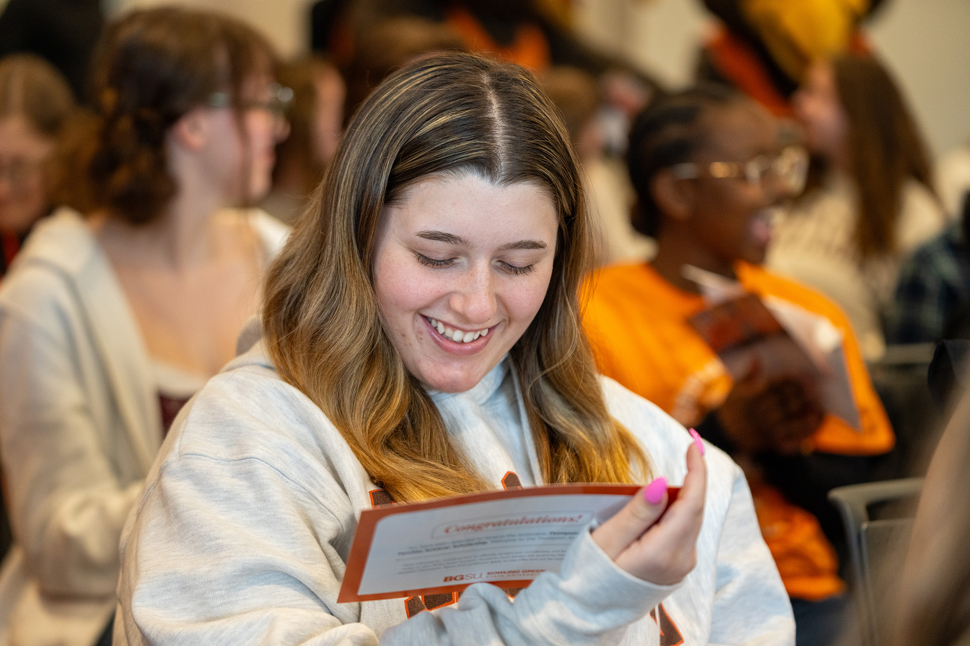 A BGSU student smiles after receiving a scholarship