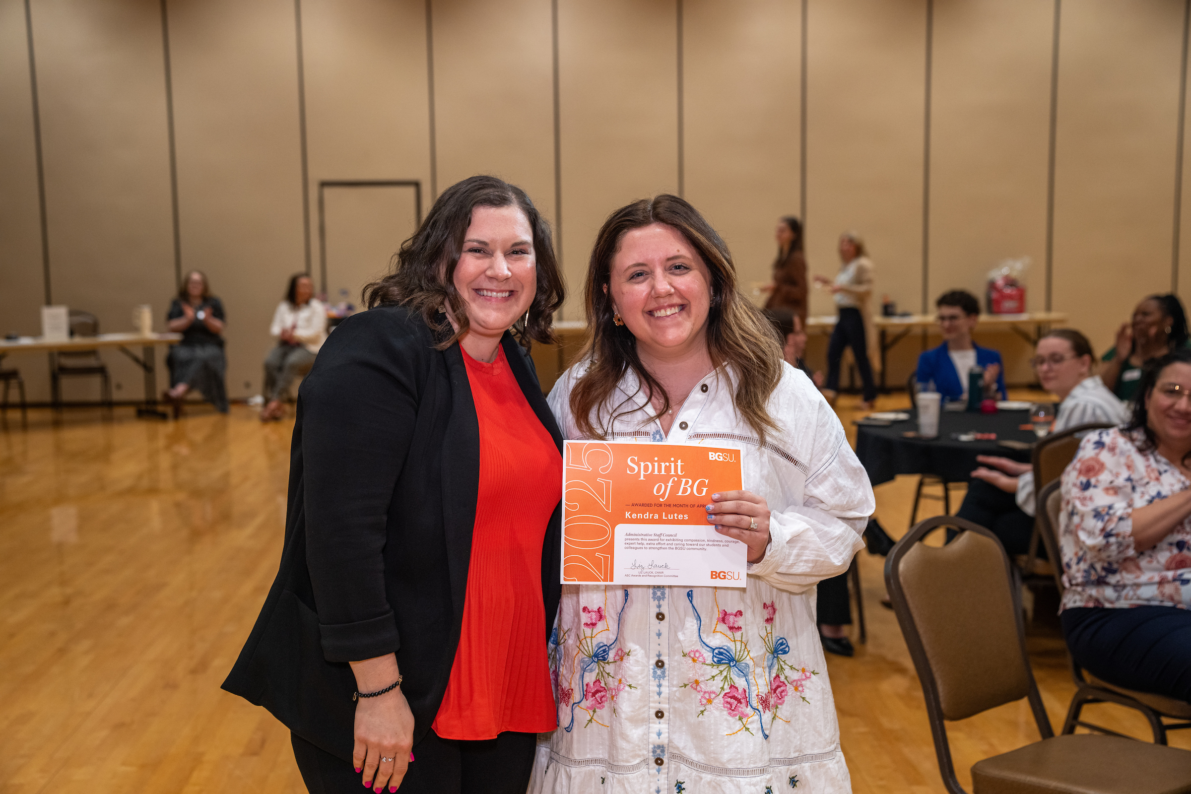 Two people pose for a photo during an awards ceremony