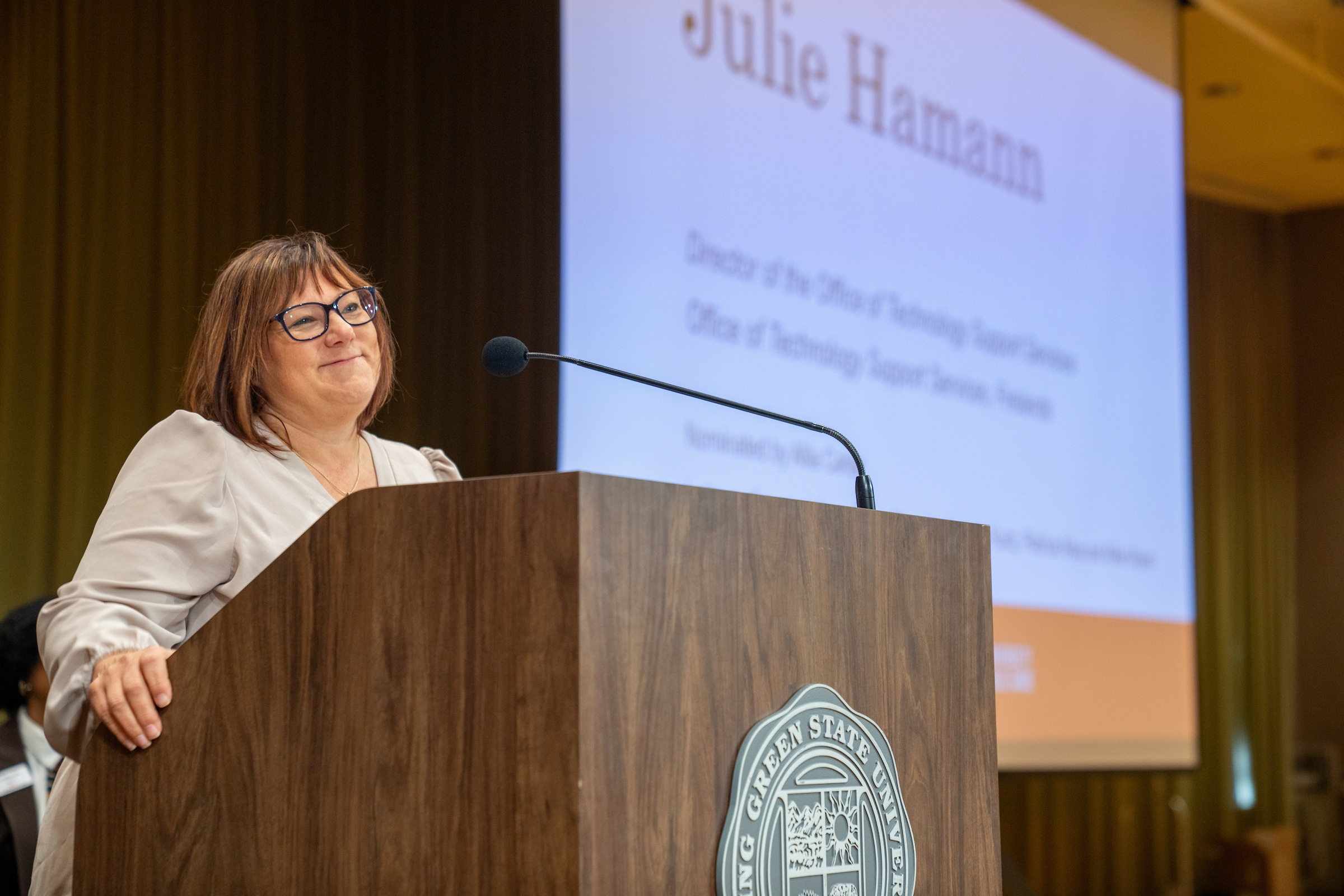 A person speaks at a podium during an awards ceremony