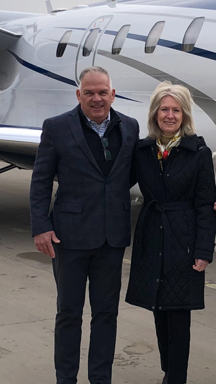 William and Mary Shelt pose for a photo in front of an airplane