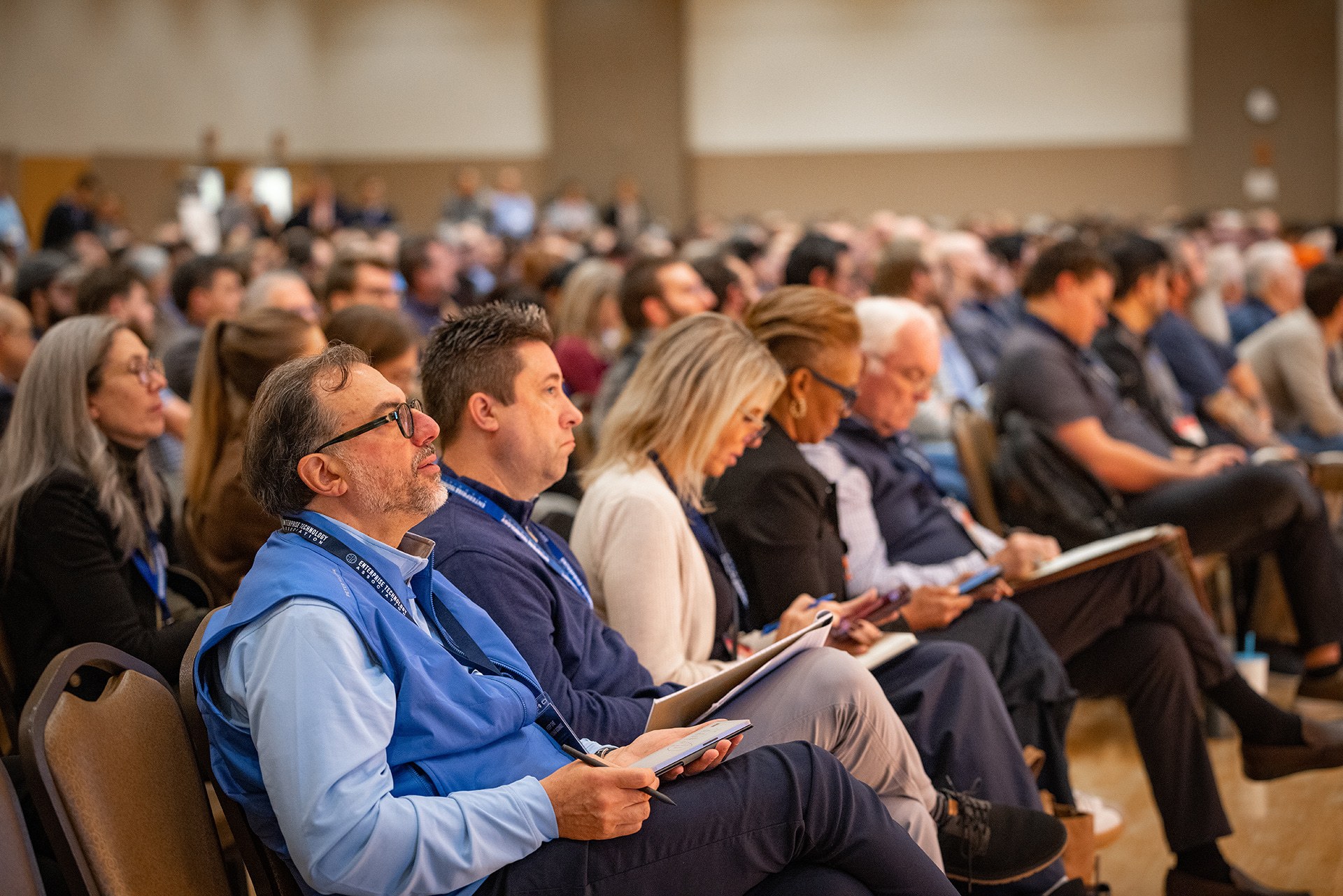 A group of people sit in the front row listening to a presenter