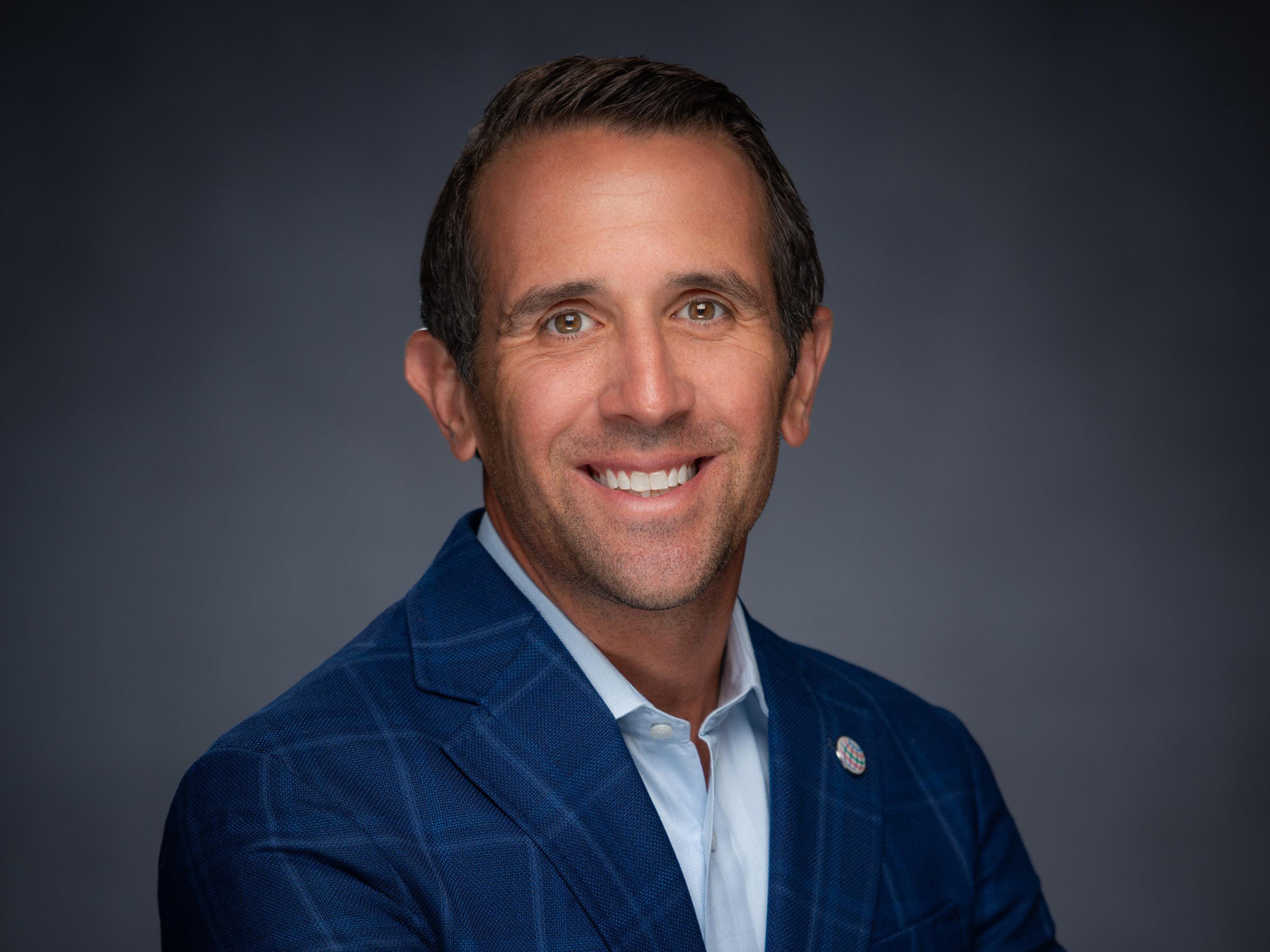 A person wearing a blue blazer poses for a photo