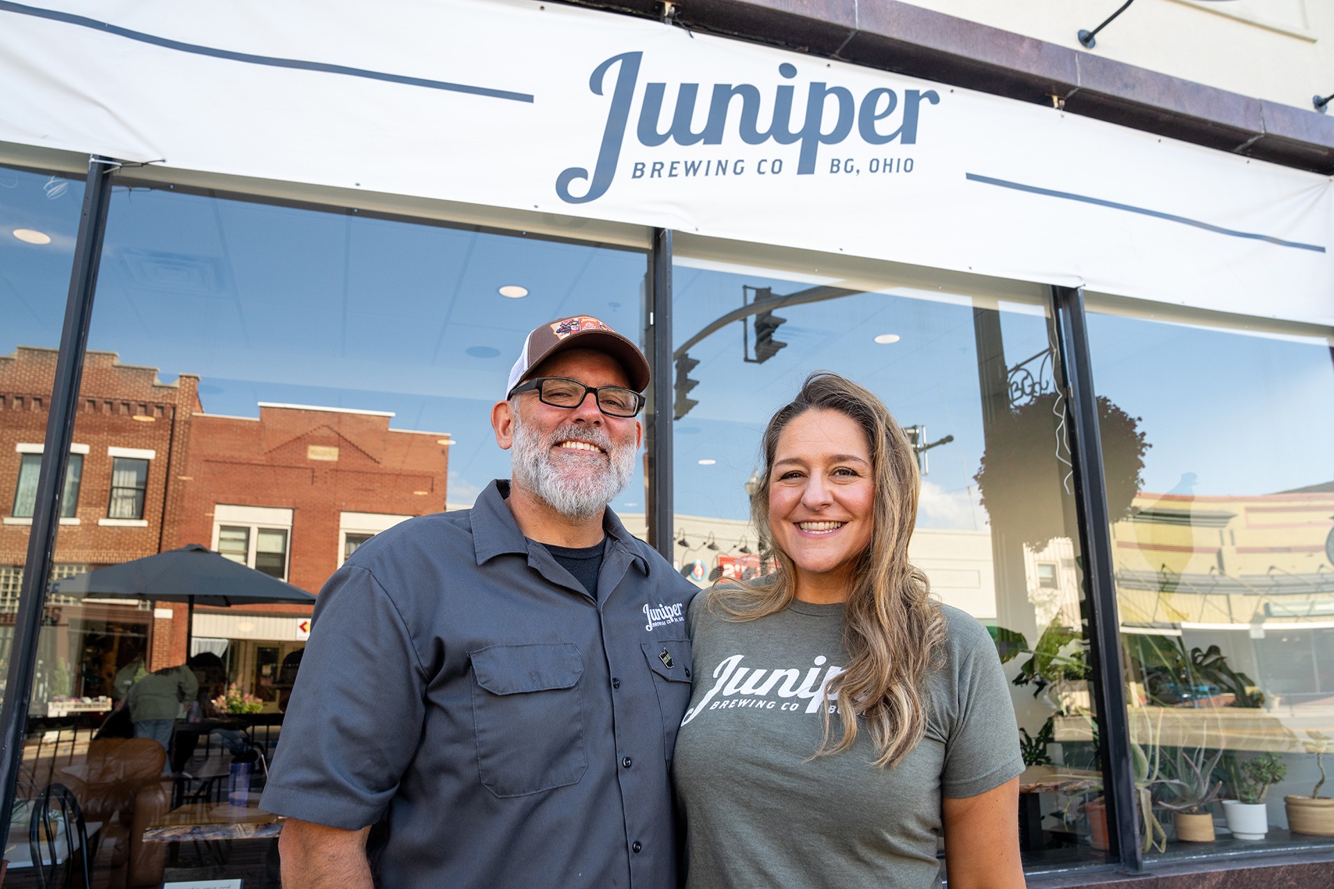 A man and a woman stand in front of a store front.