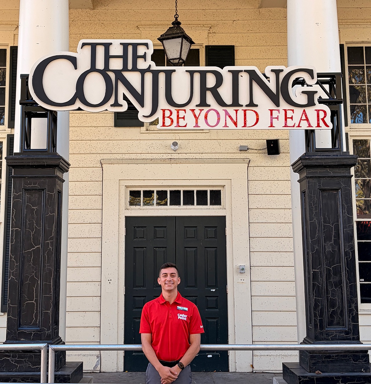 A person stands in front of the haunted attraction "The Conjuring: Beyond Fear"