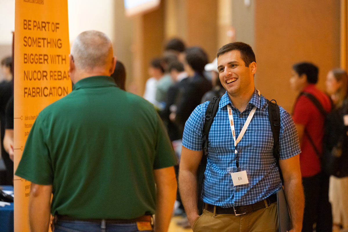 Two people talk at a career fair