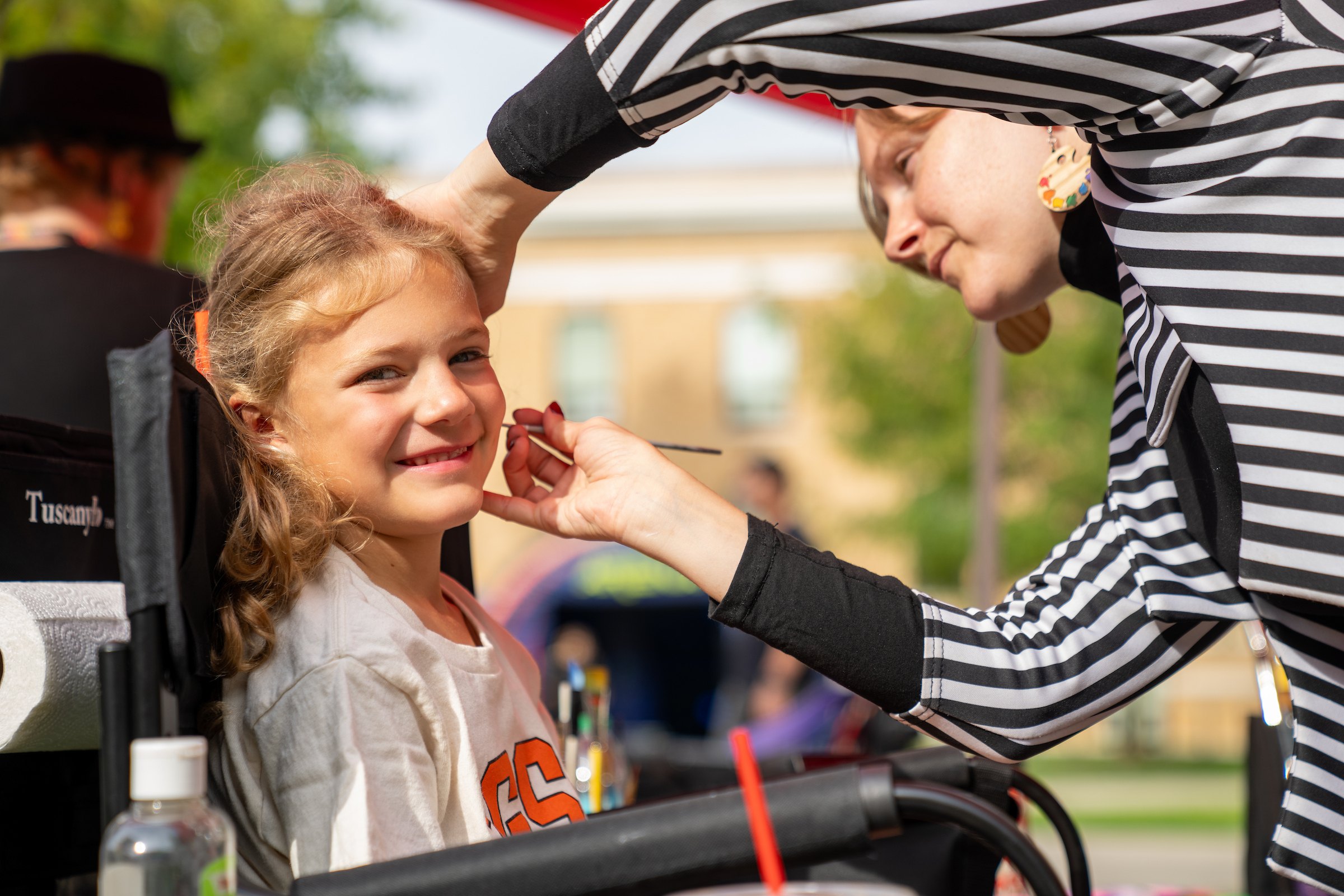 A child gets their face painted at BGSU Homecoming