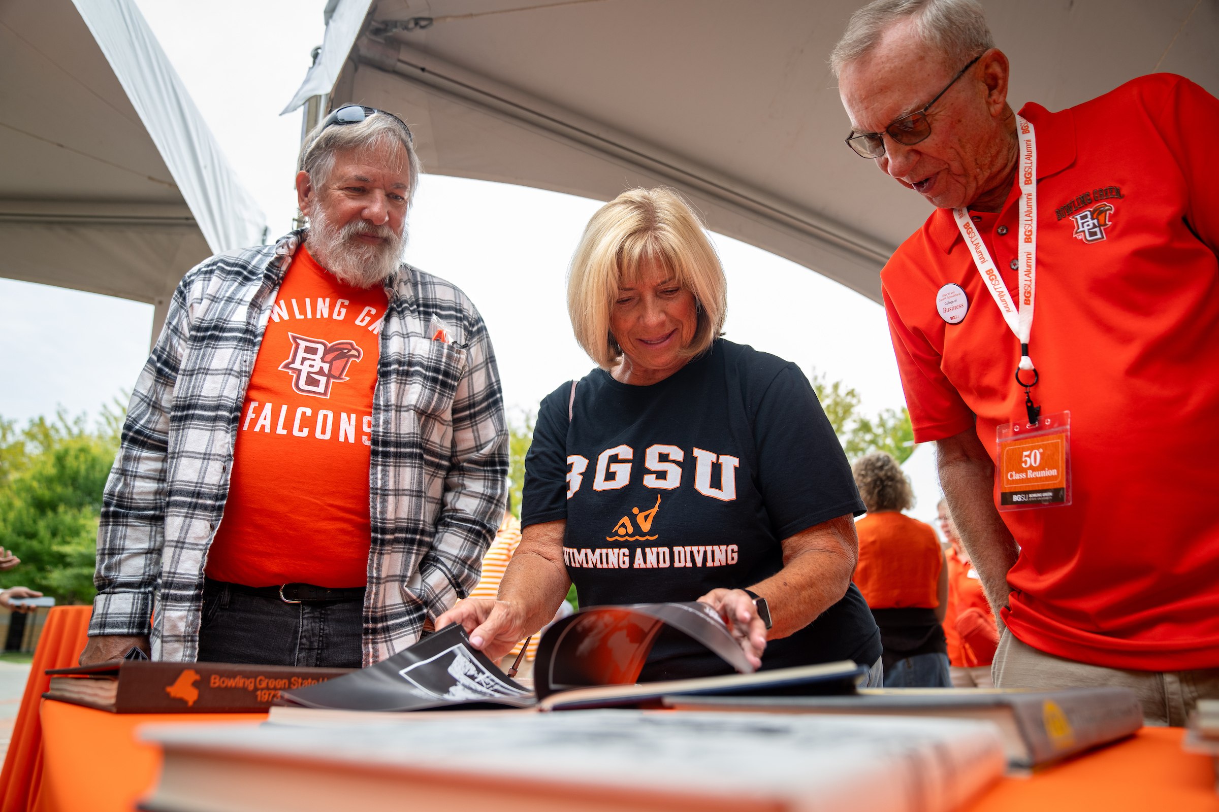 People look through yearbooks at the all-alumni celebration