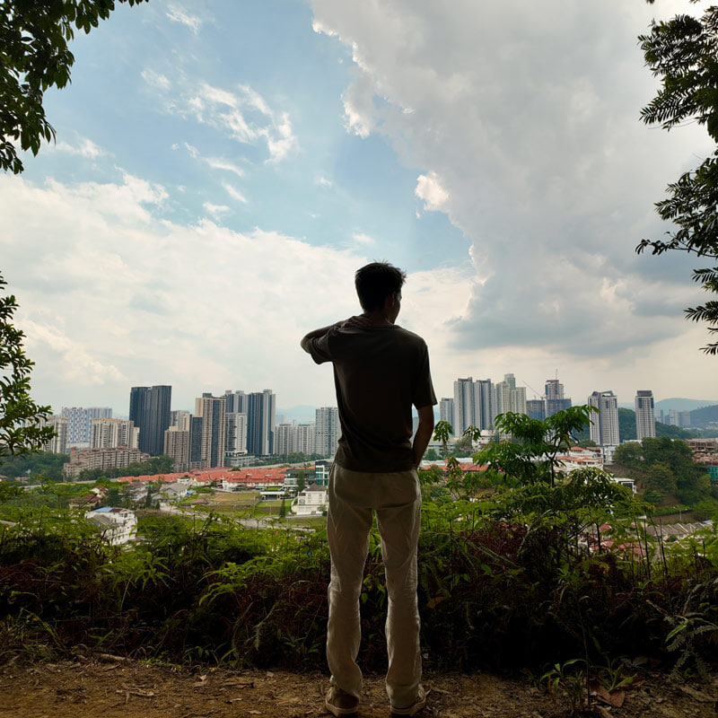  A person with his back to the camera overlooks Kuala Lumpur, Malaysia