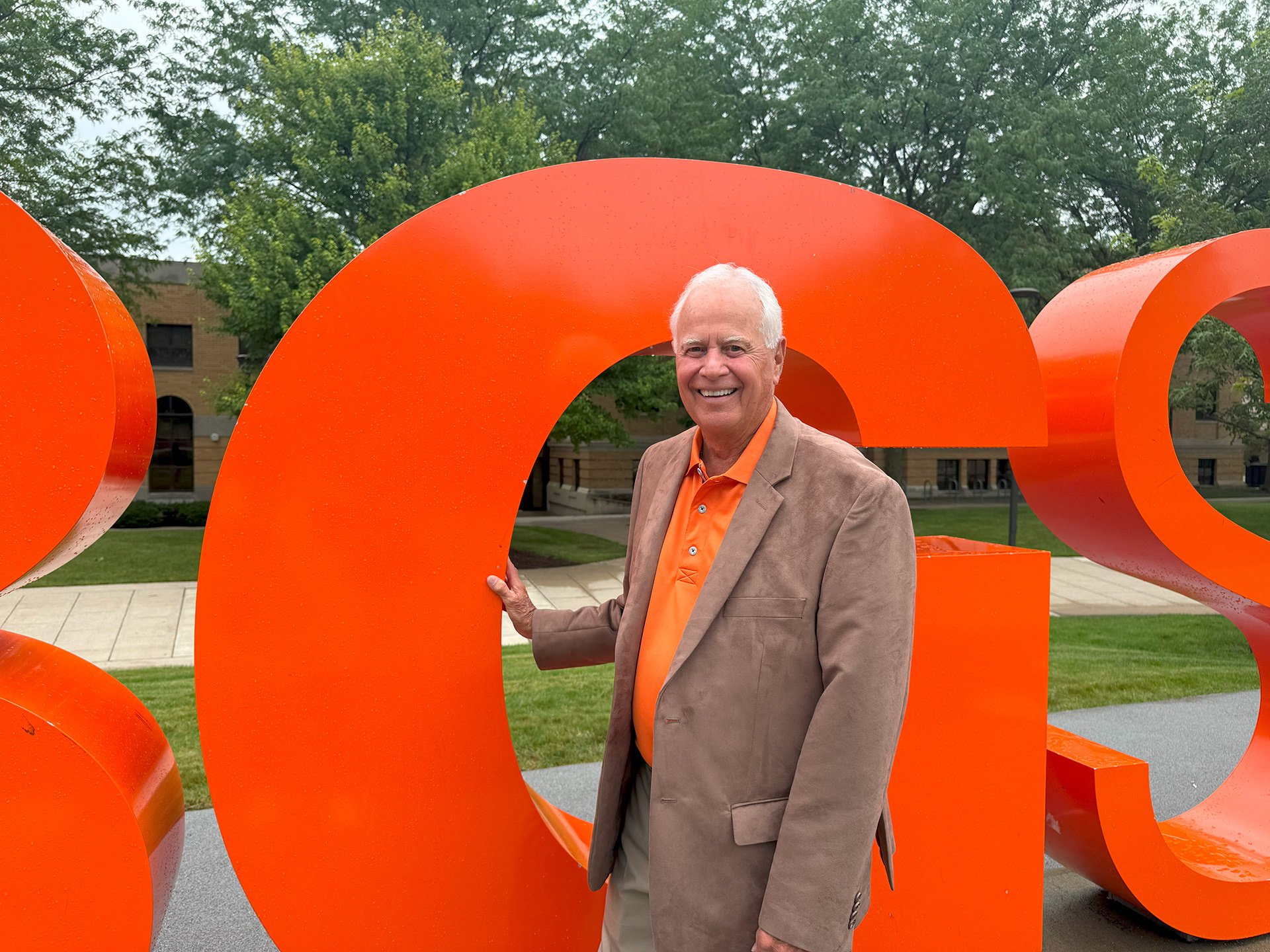 A person stands next to the BGSU letters on campus.