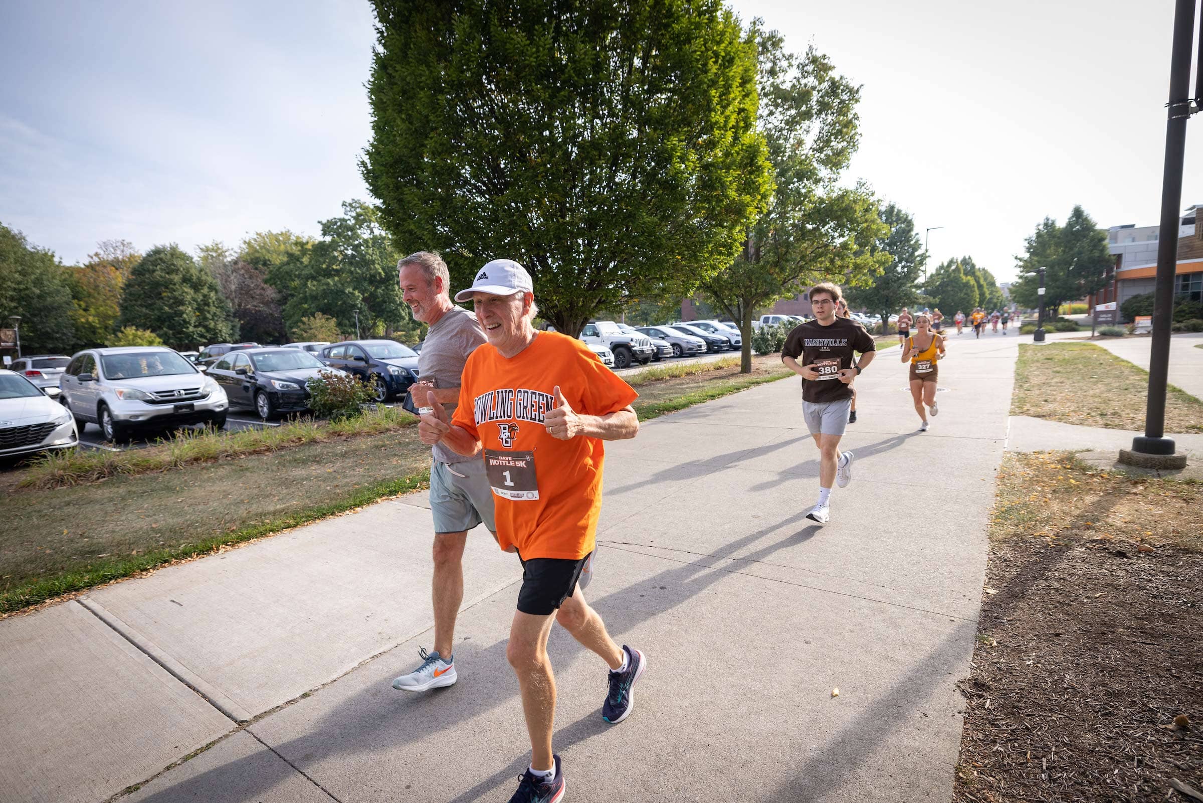 Dave Wottle raises two thumbs up as he runs 
