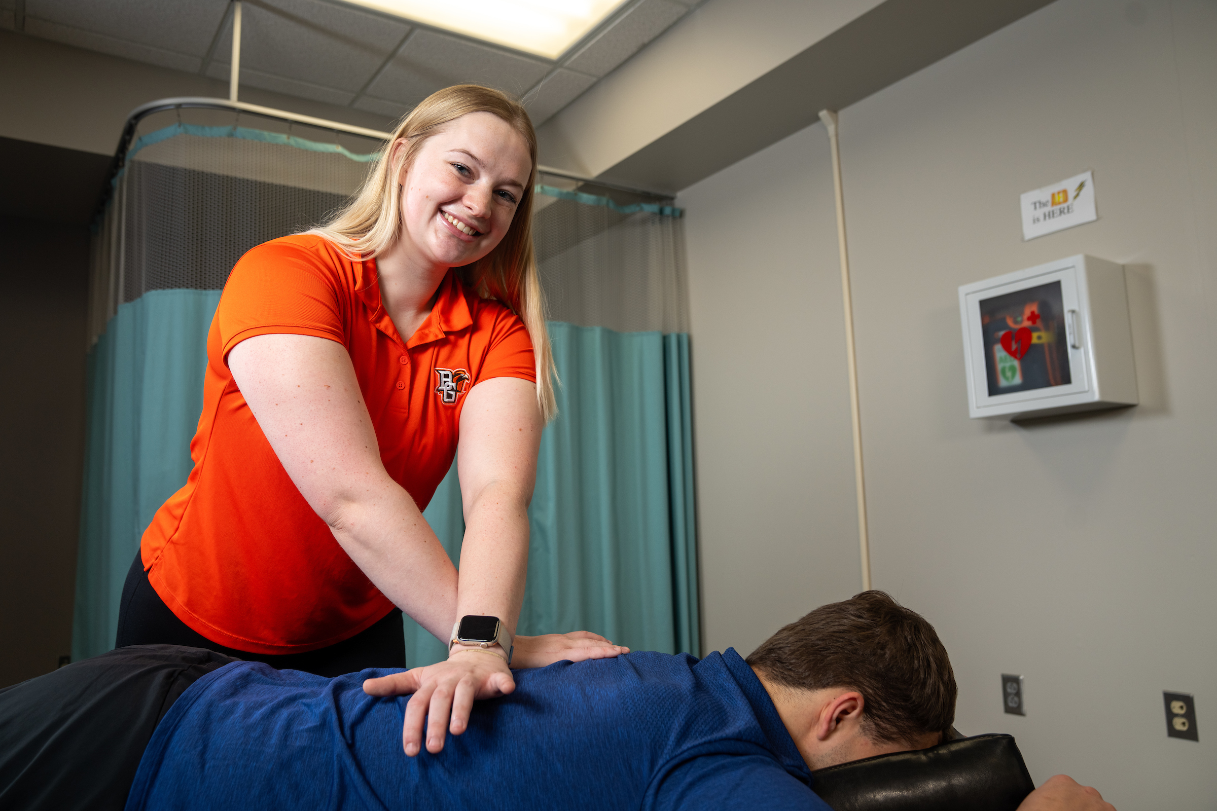 A person pushes on a patient's back