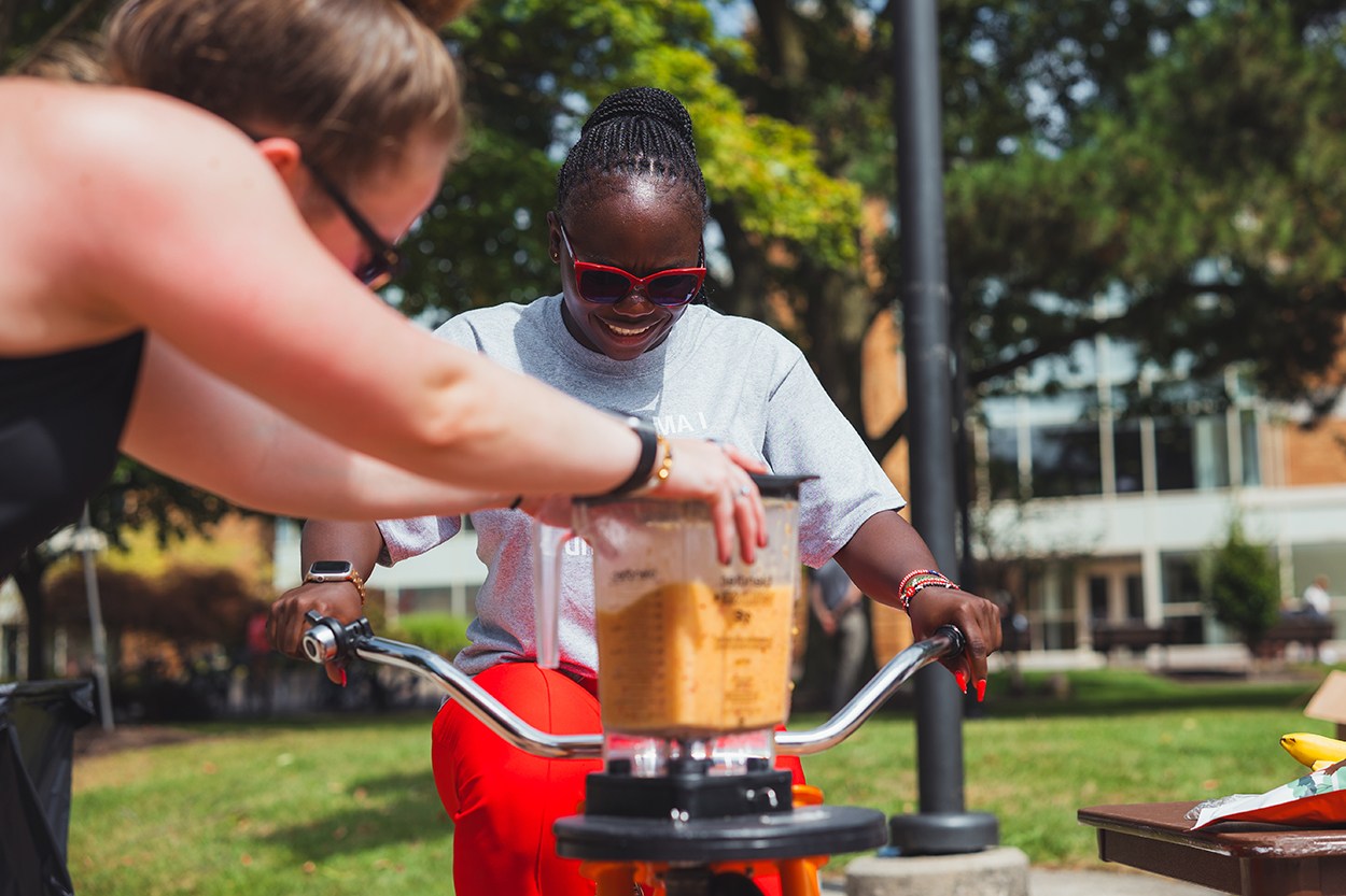 a person making a smoothie on the smoothie bike and smiling