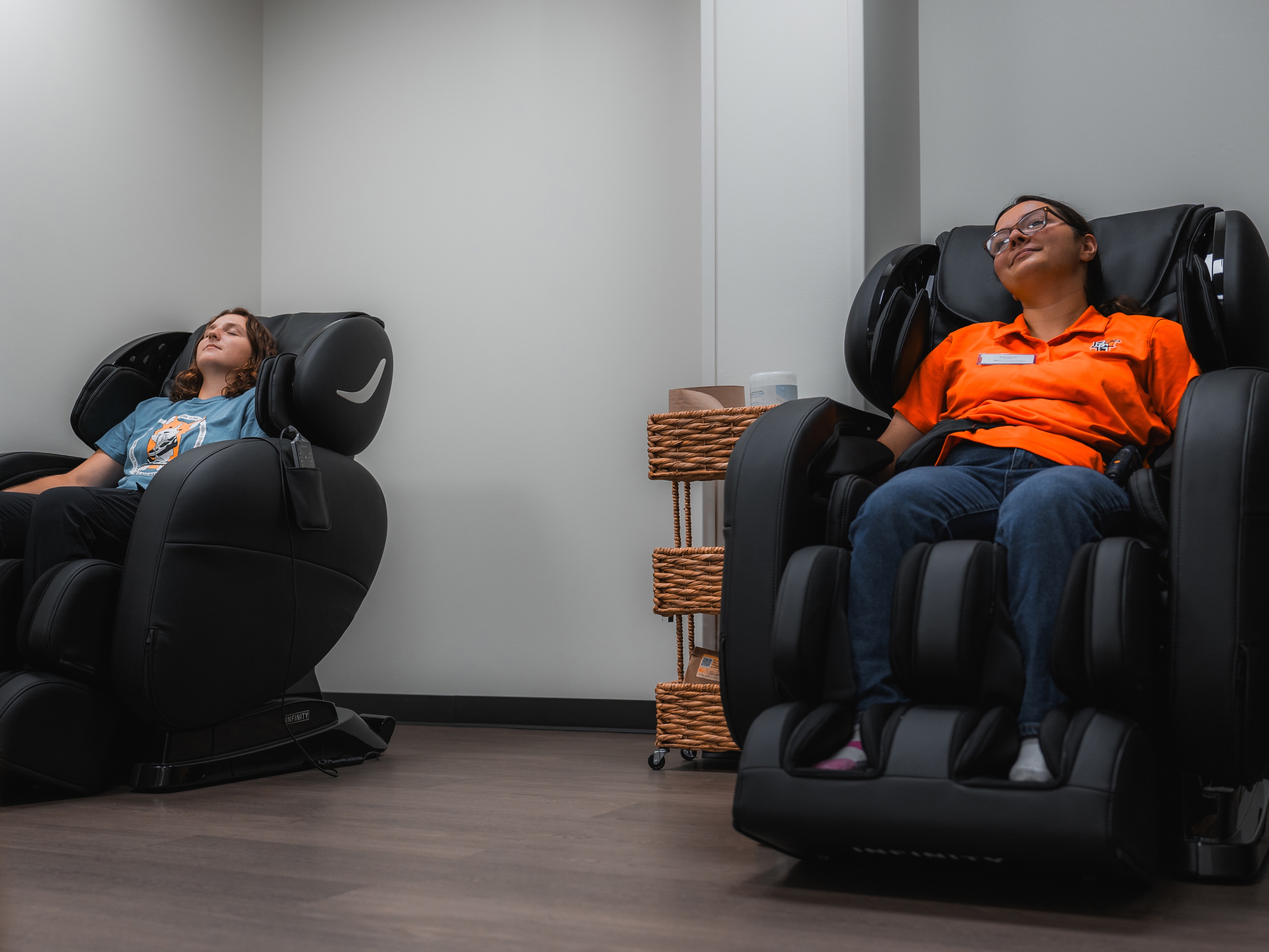 People sitting in massage chairs in Well-Being room