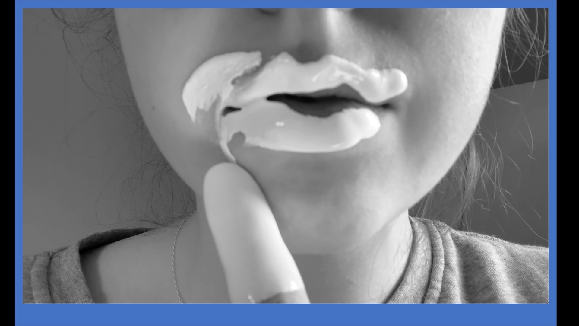 close-up photo of a mouth with thick white goop put on lips by a finger
