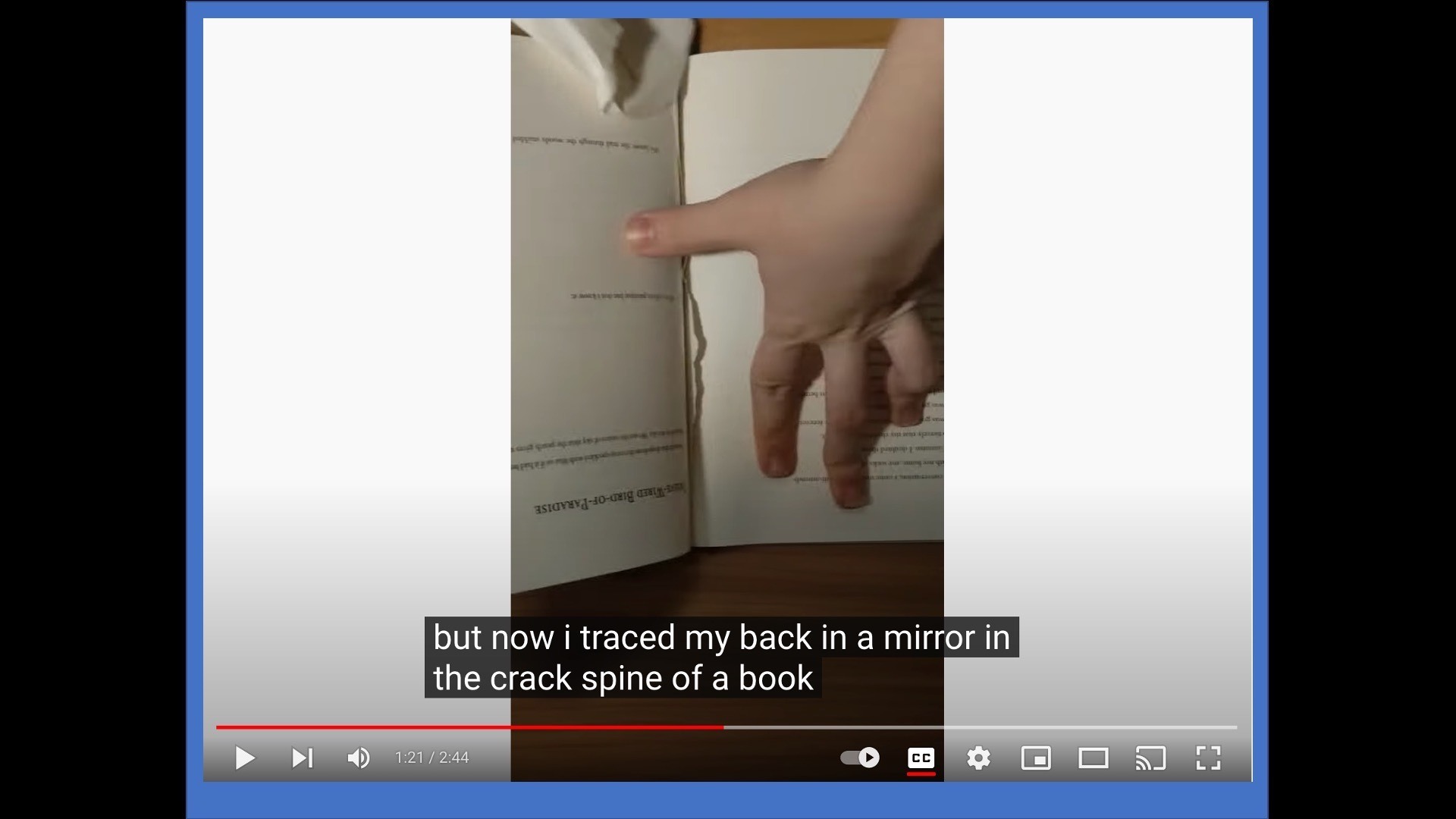 close-up photo of a spread hand pushing on the interior page of an open book]