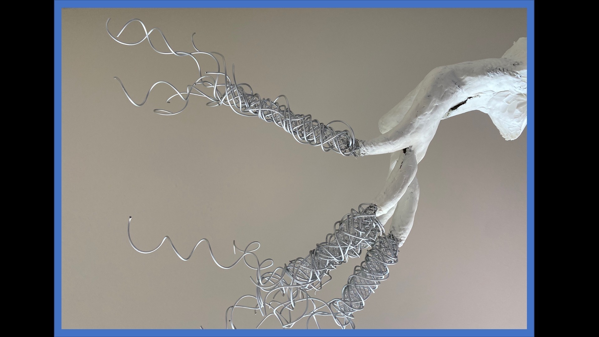 plaster cast sculpture of damaged hollow hand with long twisting wire coil extensions from fingers